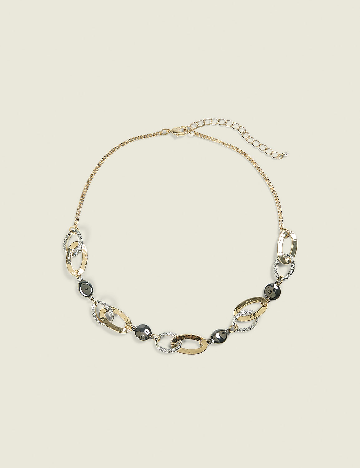 A gold-toned necklace with oval links and dark gray beads rests on a plain, light beige background. Product Image 1