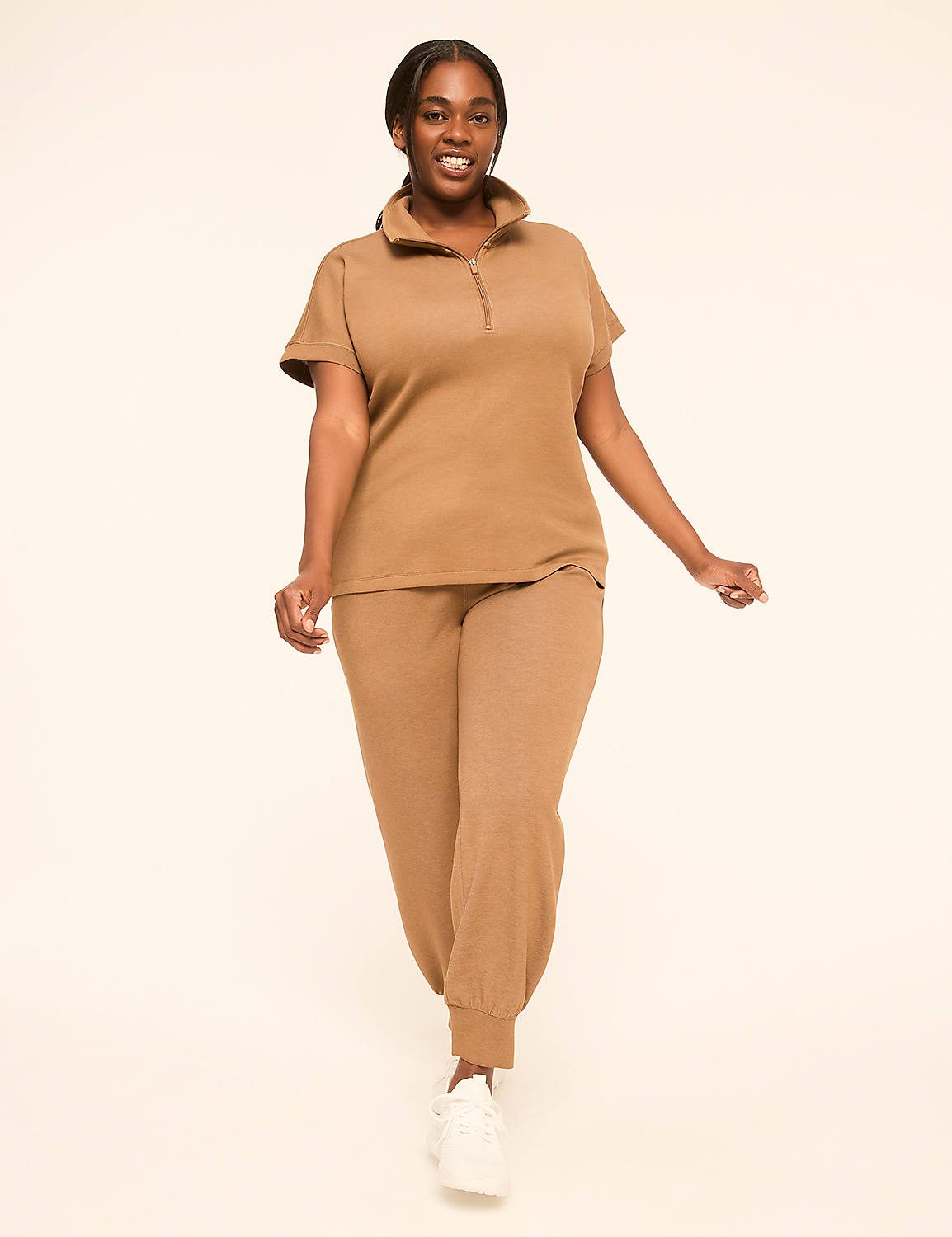 A smiling woman in a tan loungewear set walks forward against a plain, light background. Product Image 3