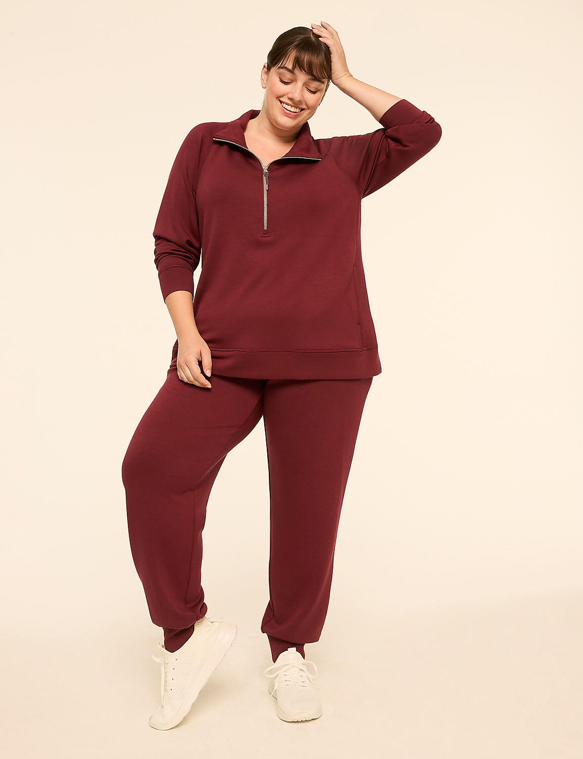 A smiling woman in a maroon tracksuit stands against a plain, light-colored background. Product Image 3