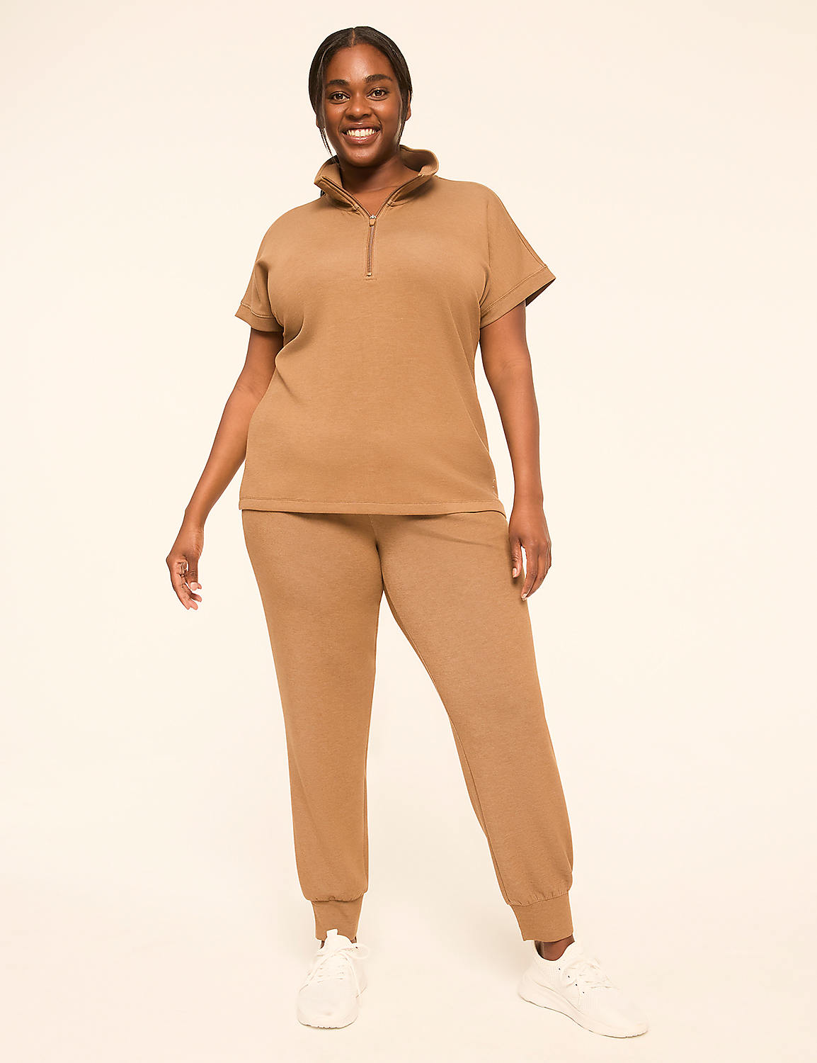 A smiling woman in a tan loungewear set stands against a plain, light-colored background. Product Image 3