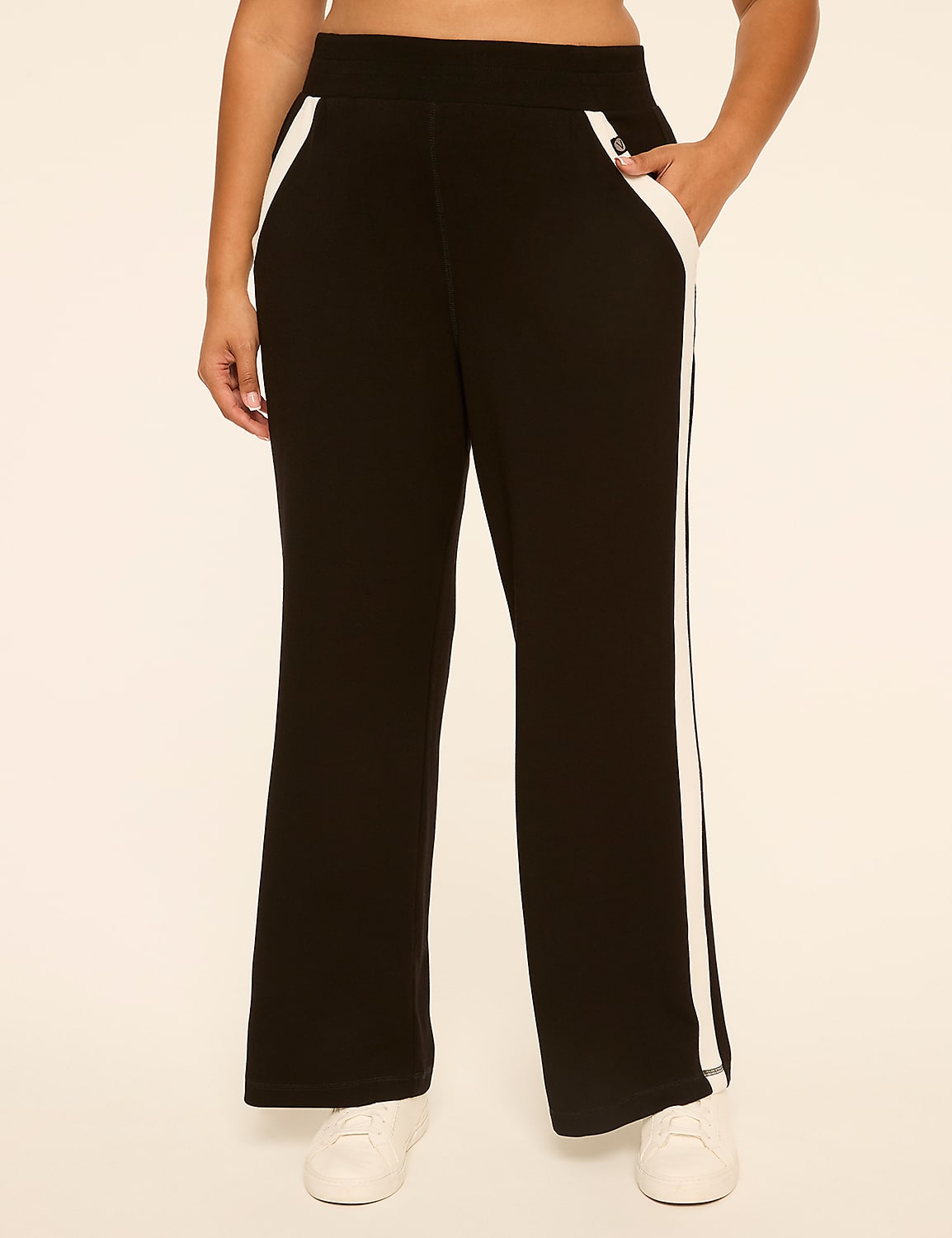 A person wearing black athletic pants with white stripes stands against a plain, light-colored background. Product Image 1