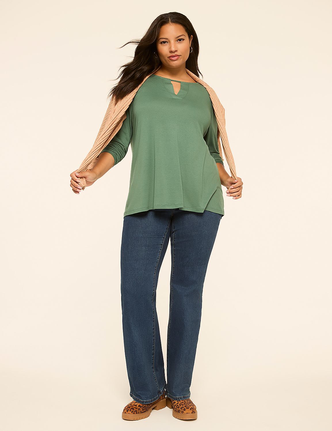 A woman in a green top and blue jeans stands against a plain, light-colored background with a peach-colored scarf draped over her shoulders. Product Image 3