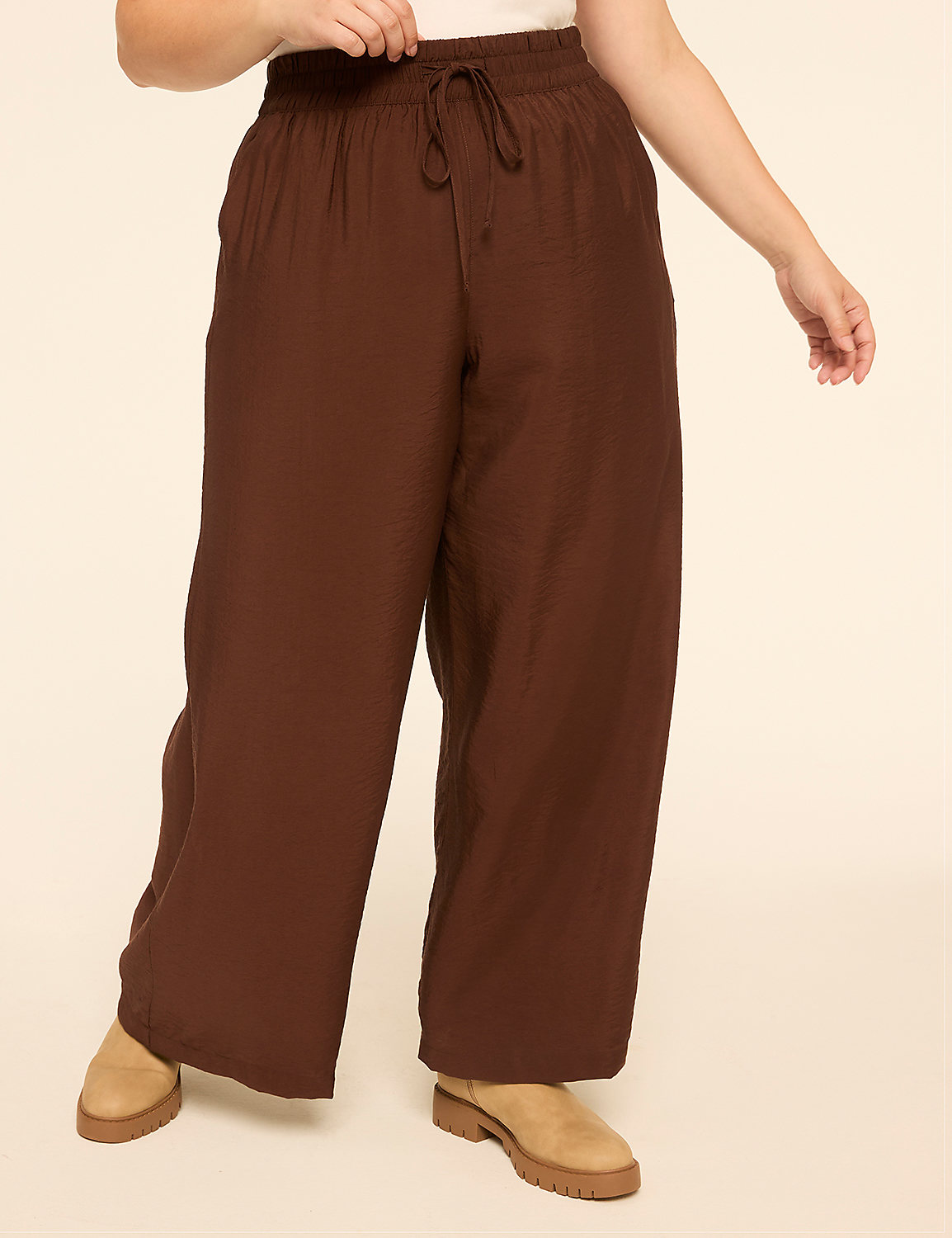 A person wearing brown wide-leg pants and sandals stands against a plain beige background. Product Image 1