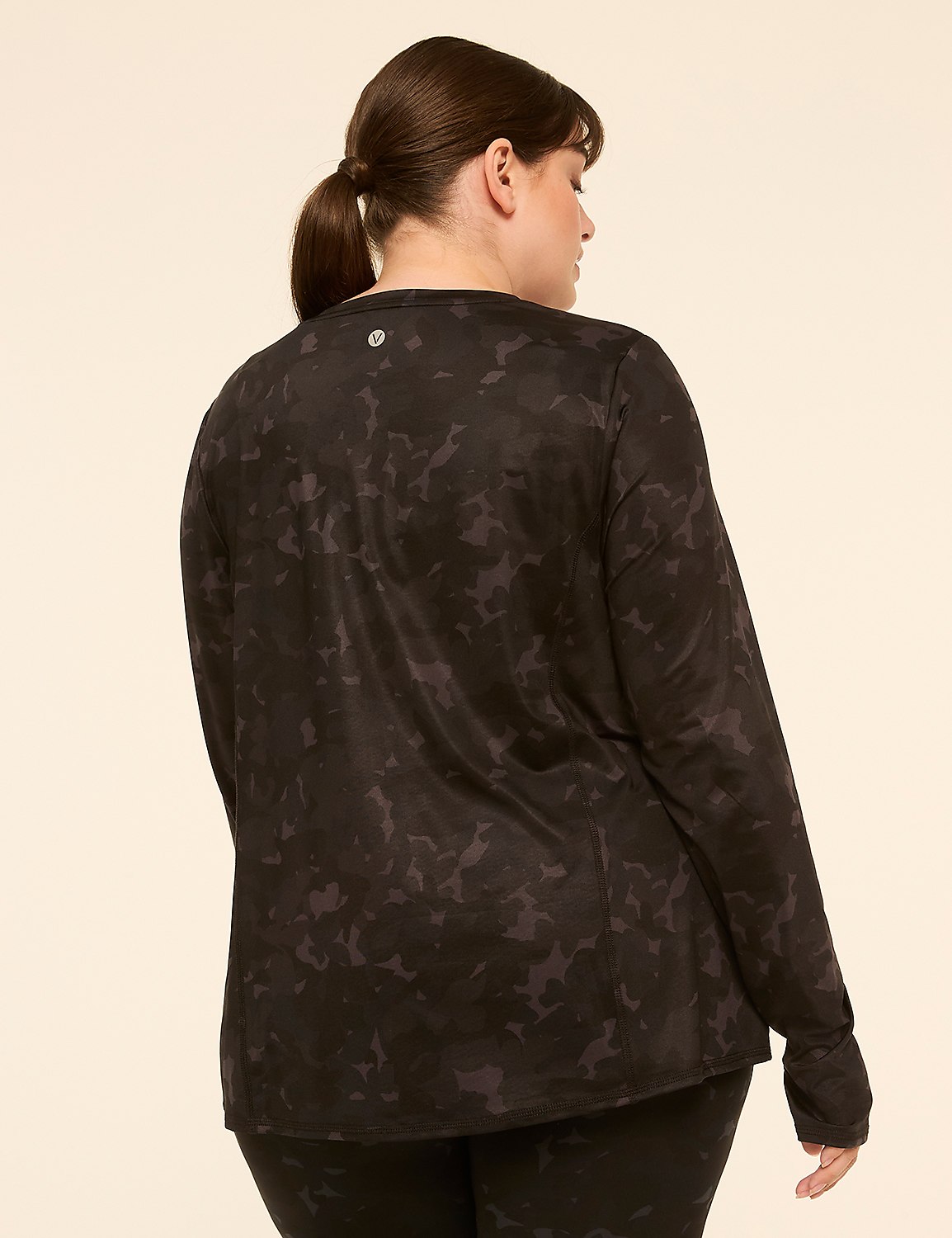 A woman in a black camouflage long-sleeved shirt stands against a plain, light-colored background. Product Image 2