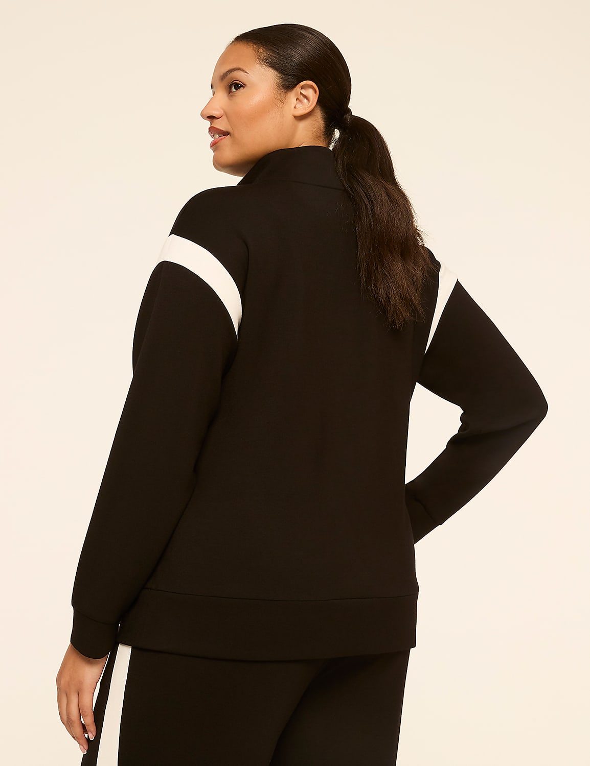 A woman in a black and white athletic jacket stands against a plain, light-colored background. Product Image 2