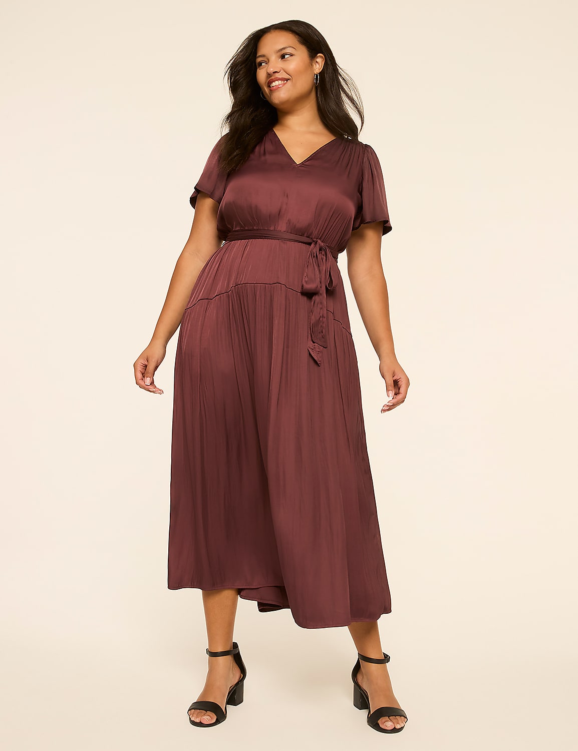 A woman in a burgundy dress stands against a plain, light-colored background. Product Image 1