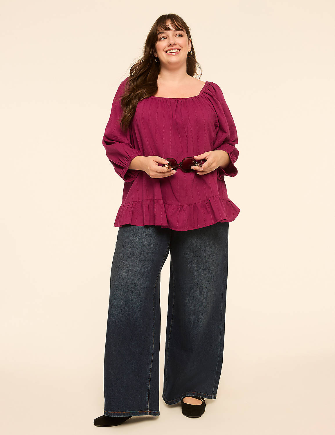 A smiling woman in a magenta peasant top and wide-leg jeans stands against a plain, light-colored background. Product Image 3