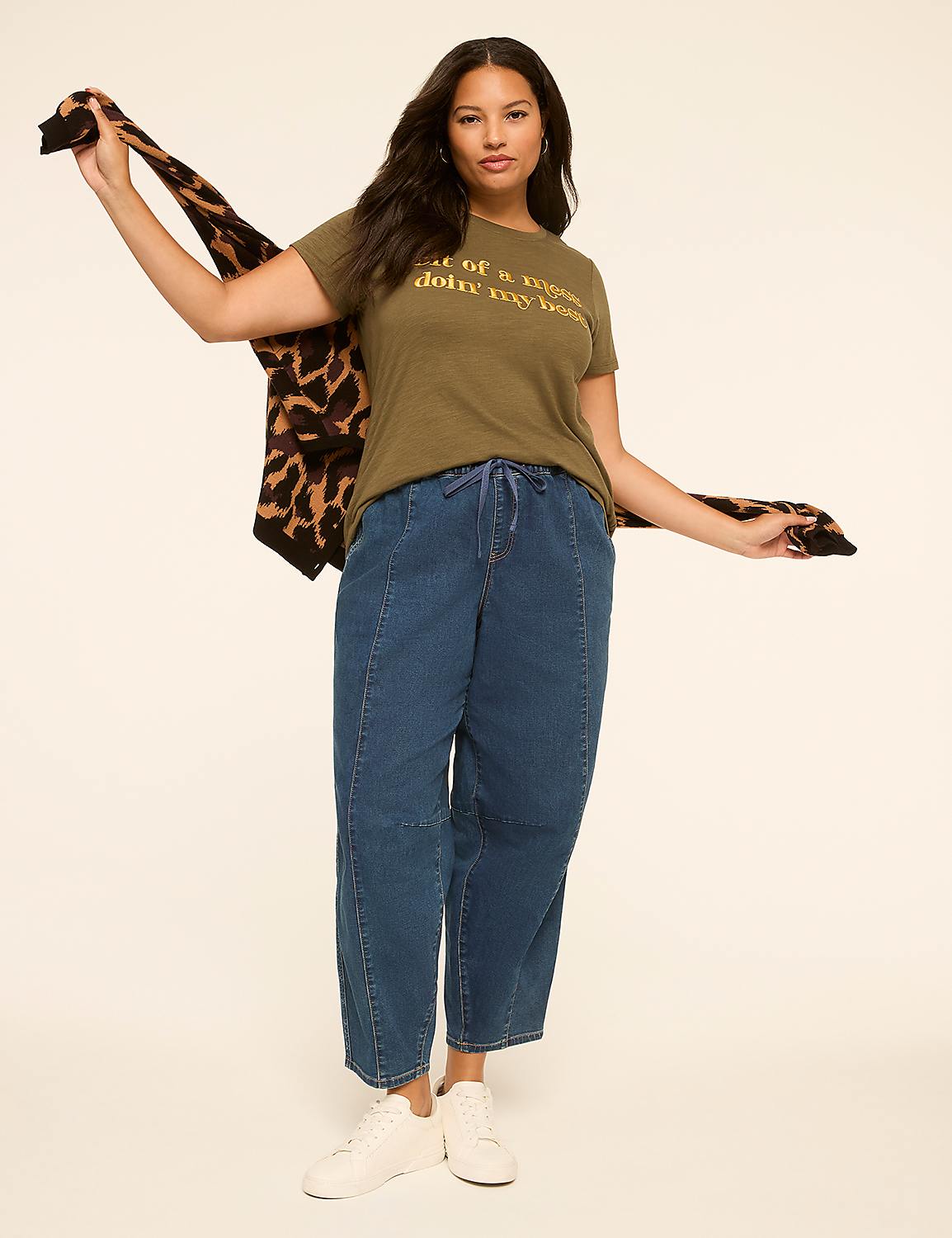 A woman in a green t-shirt and blue jeans poses with a leopard-print cardigan draped over her shoulders against a plain, light-colored background. Product Image 3