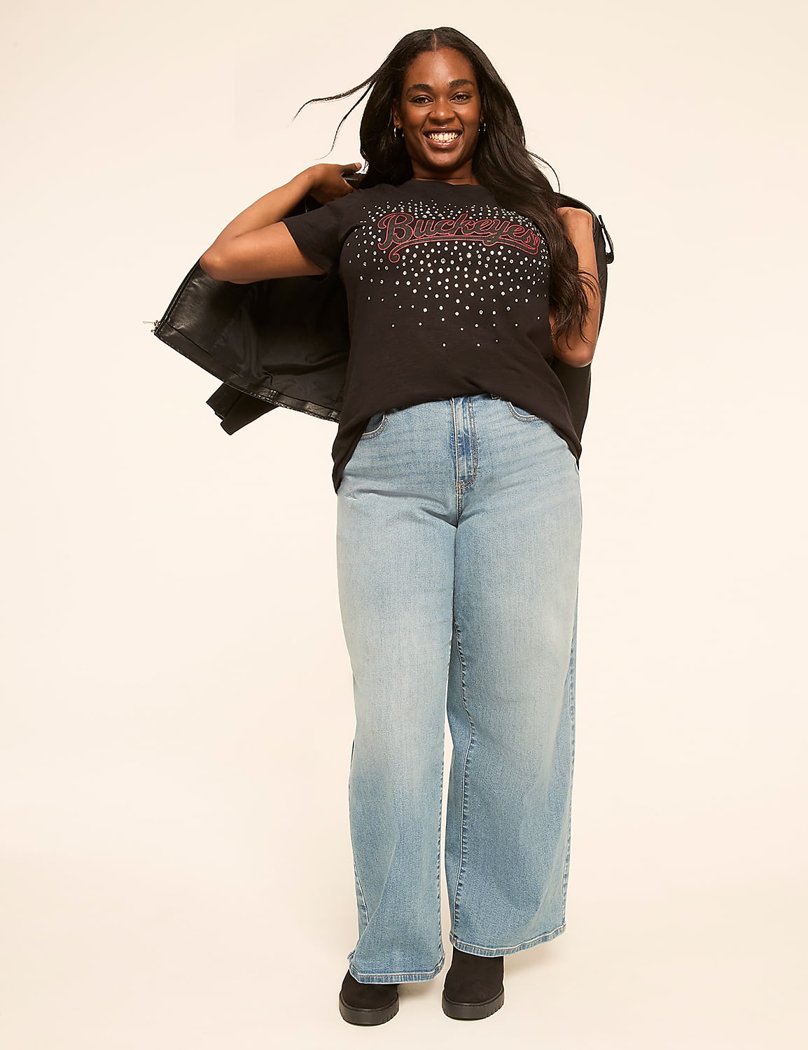 A smiling woman in a sparkly t-shirt and wide-leg jeans stands against a plain, light-colored background. Product Image 3