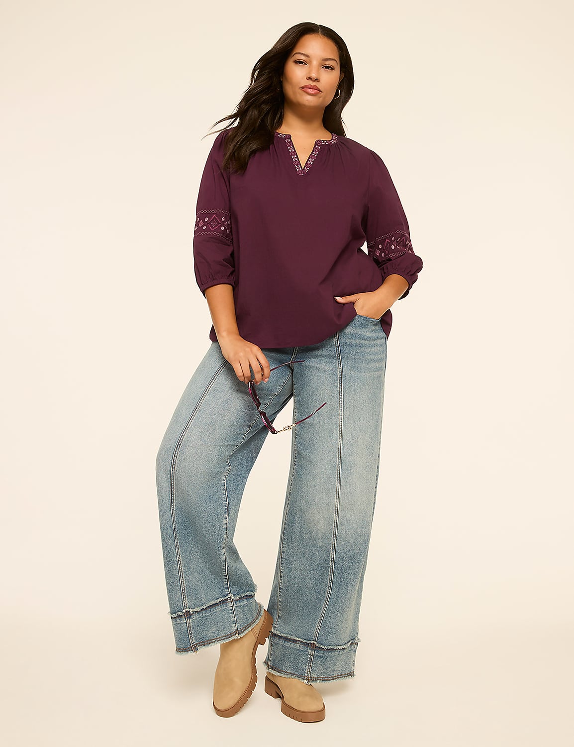 A woman in a purple top and wide-leg jeans stands against a plain, light-colored background. Product Image 3