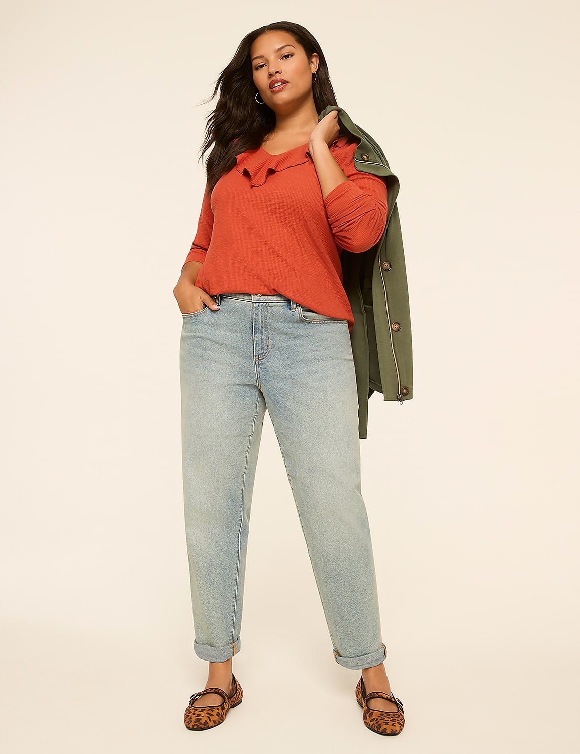A woman in a rust-colored ruffled top and light-wash jeans stands against a plain, light-colored background. Product Image 3