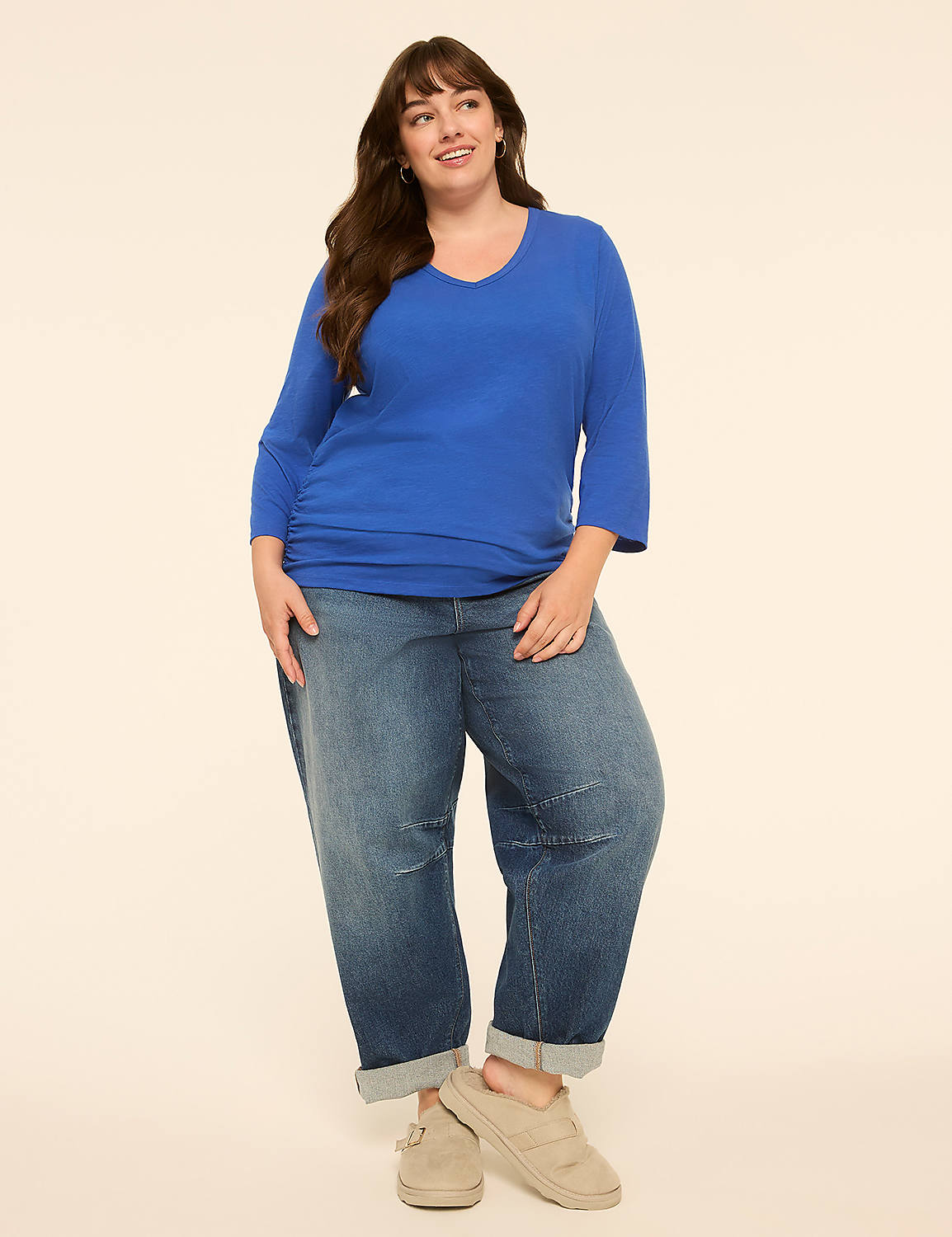 A woman in a blue shirt and baggy jeans stands against a plain, light-colored background. Product Image 3