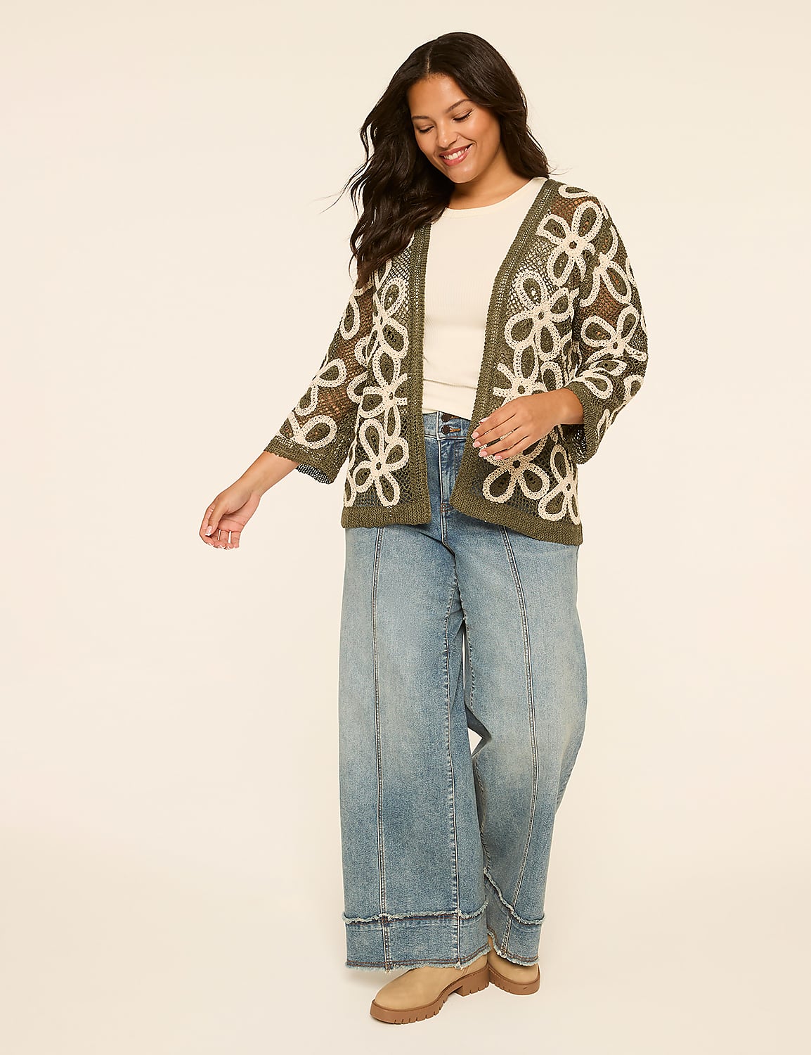 A smiling woman in a floral cardigan and wide-leg jeans stands against a plain, light-colored background. Product Image 3