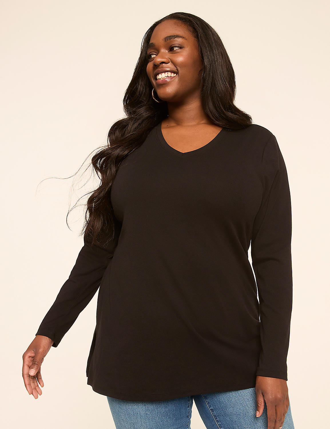 A smiling woman with long dark hair wears a black v-neck long-sleeved shirt and blue jeans against a plain, light-colored background. Product Image 1