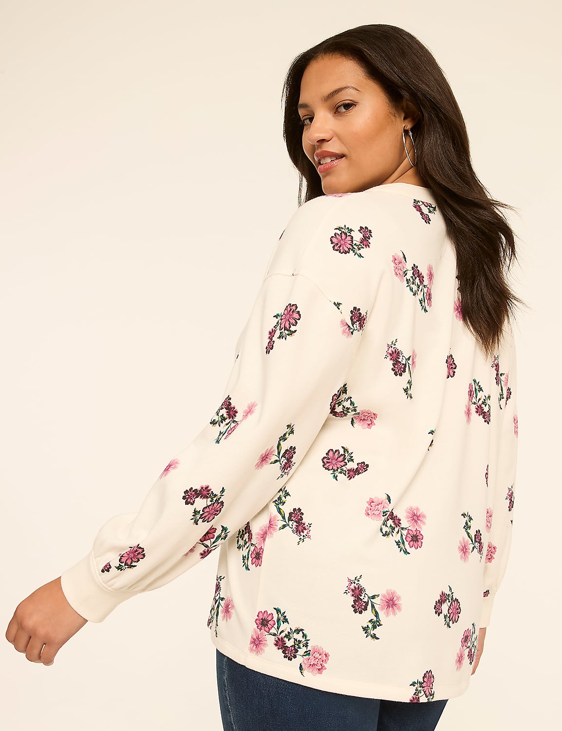 A woman in a floral print sweater turns her back to the camera against a plain, light background. Product Image 2