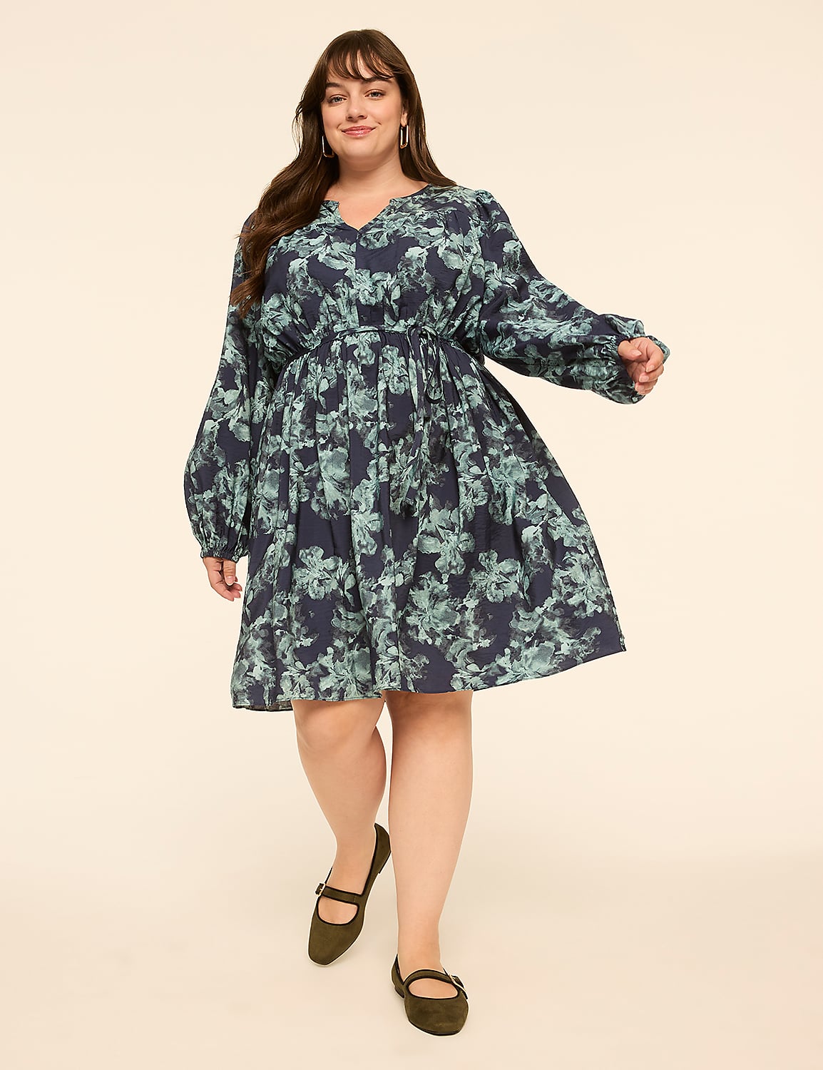 A woman in a floral dress and flats stands against a plain, light-colored background. Product Image 1