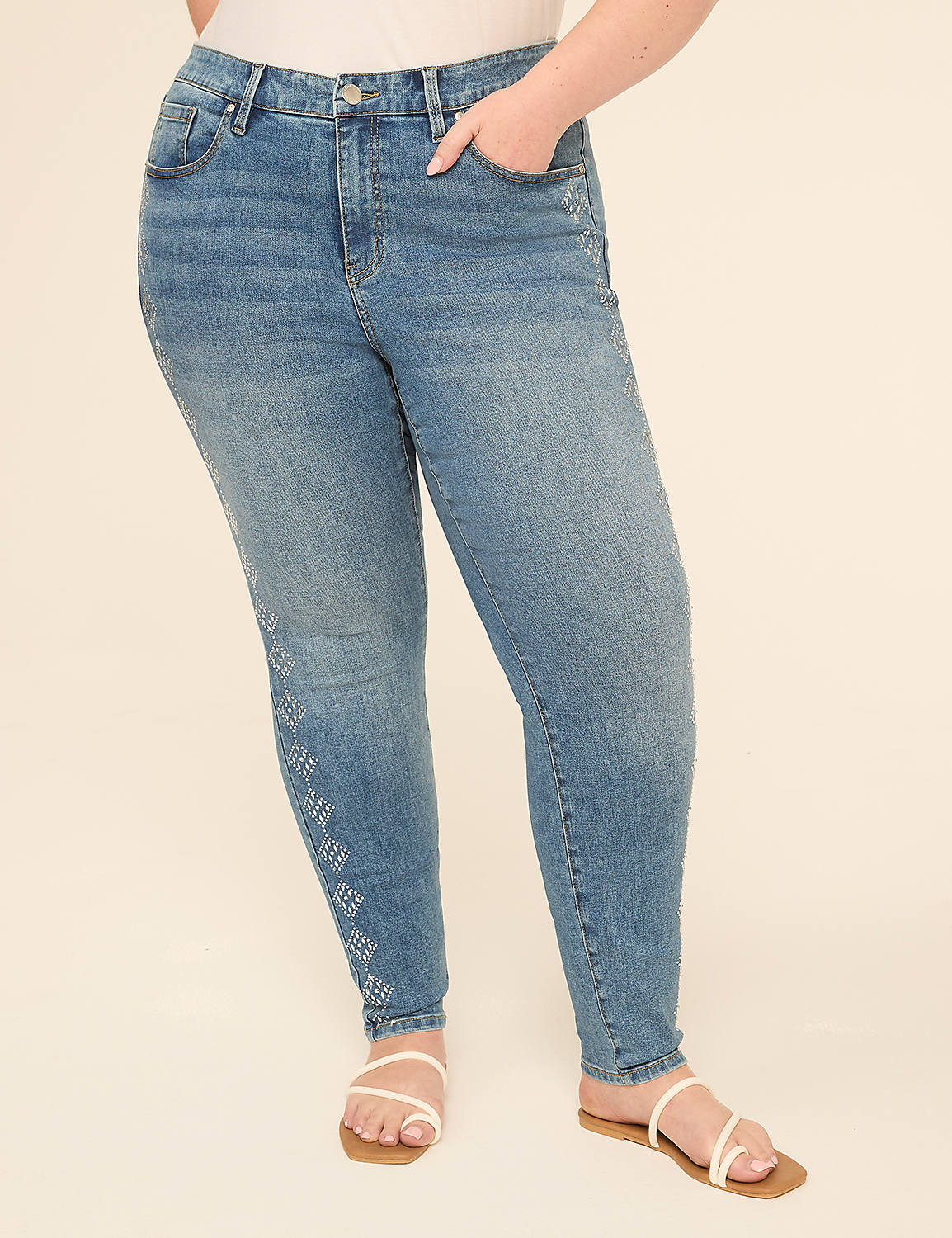 A person in light blue jeans with a diamond pattern on the left leg stands against a plain, light beige background. Product Image 1