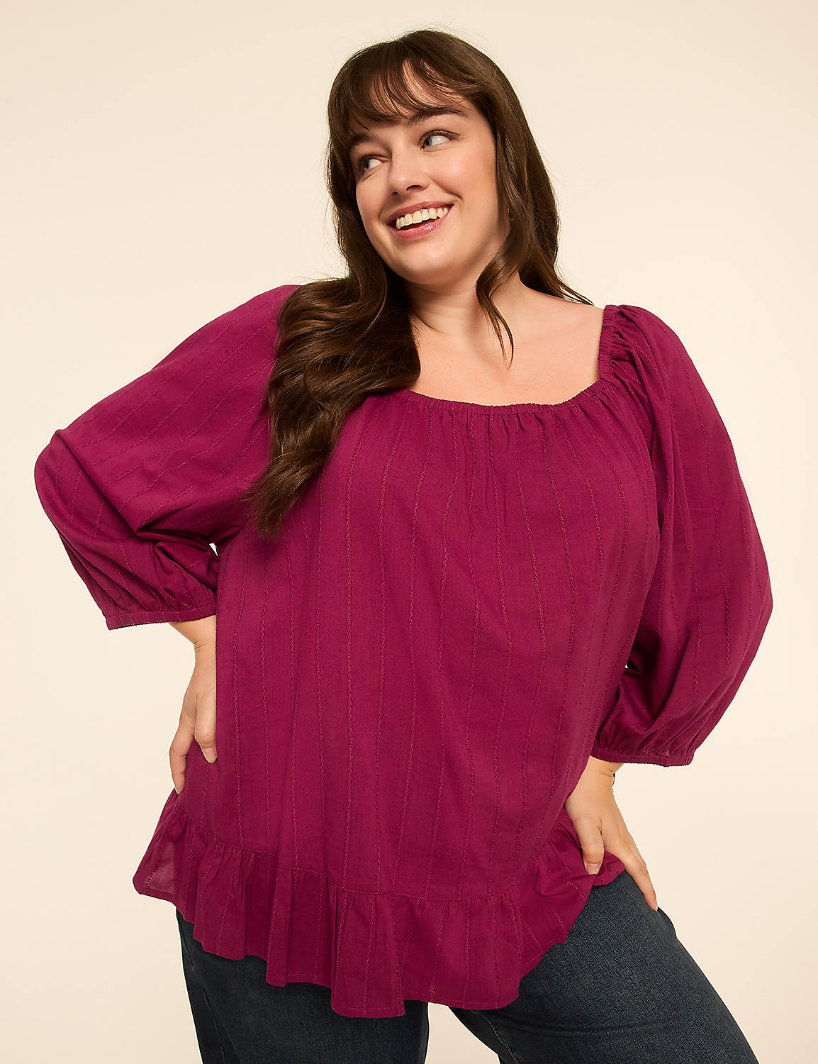 A smiling woman in a magenta peasant blouse stands against a plain cream background. Product Image 1