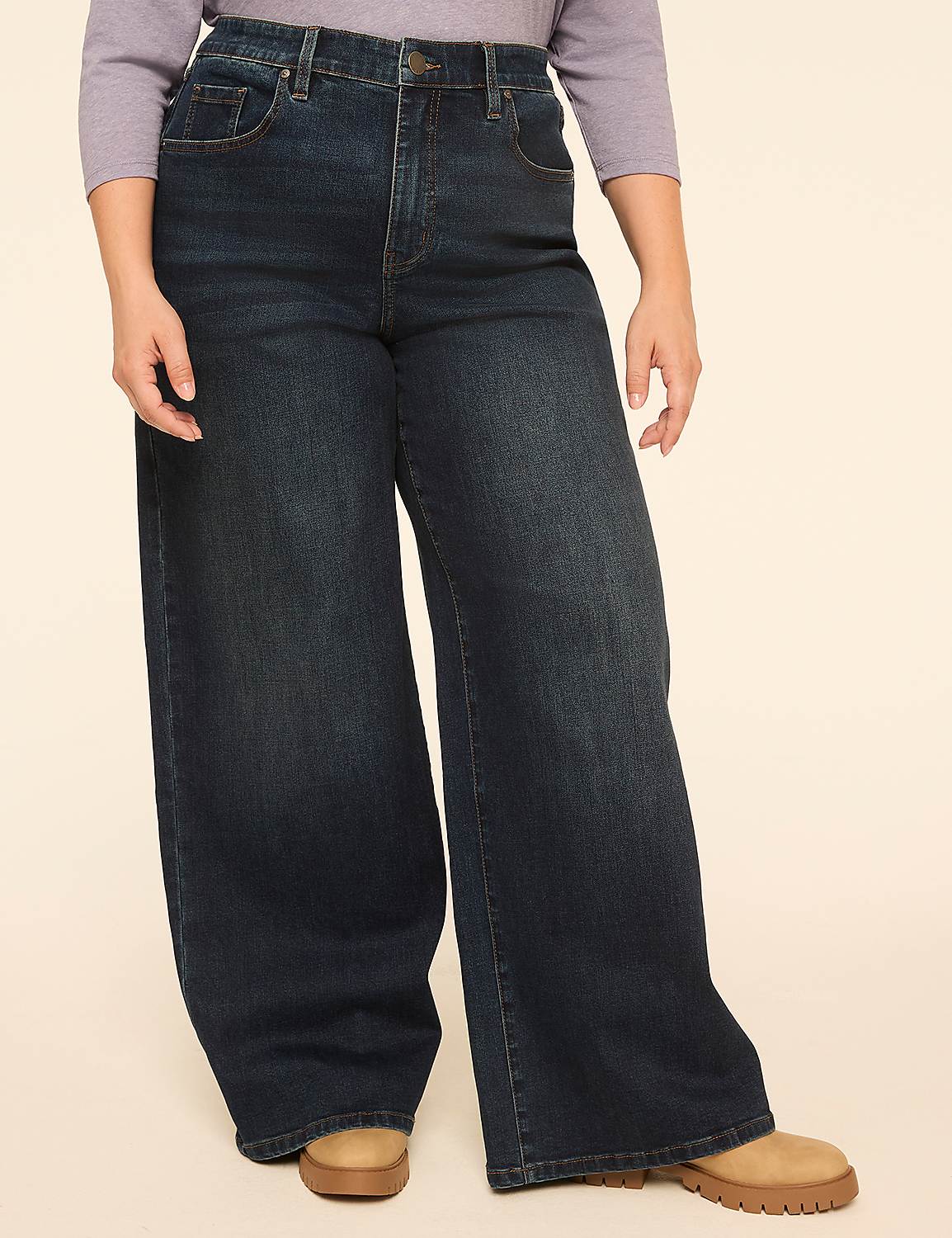 A person wearing dark wash wide-leg jeans and a light purple top stands against a plain beige background. Product Image 1