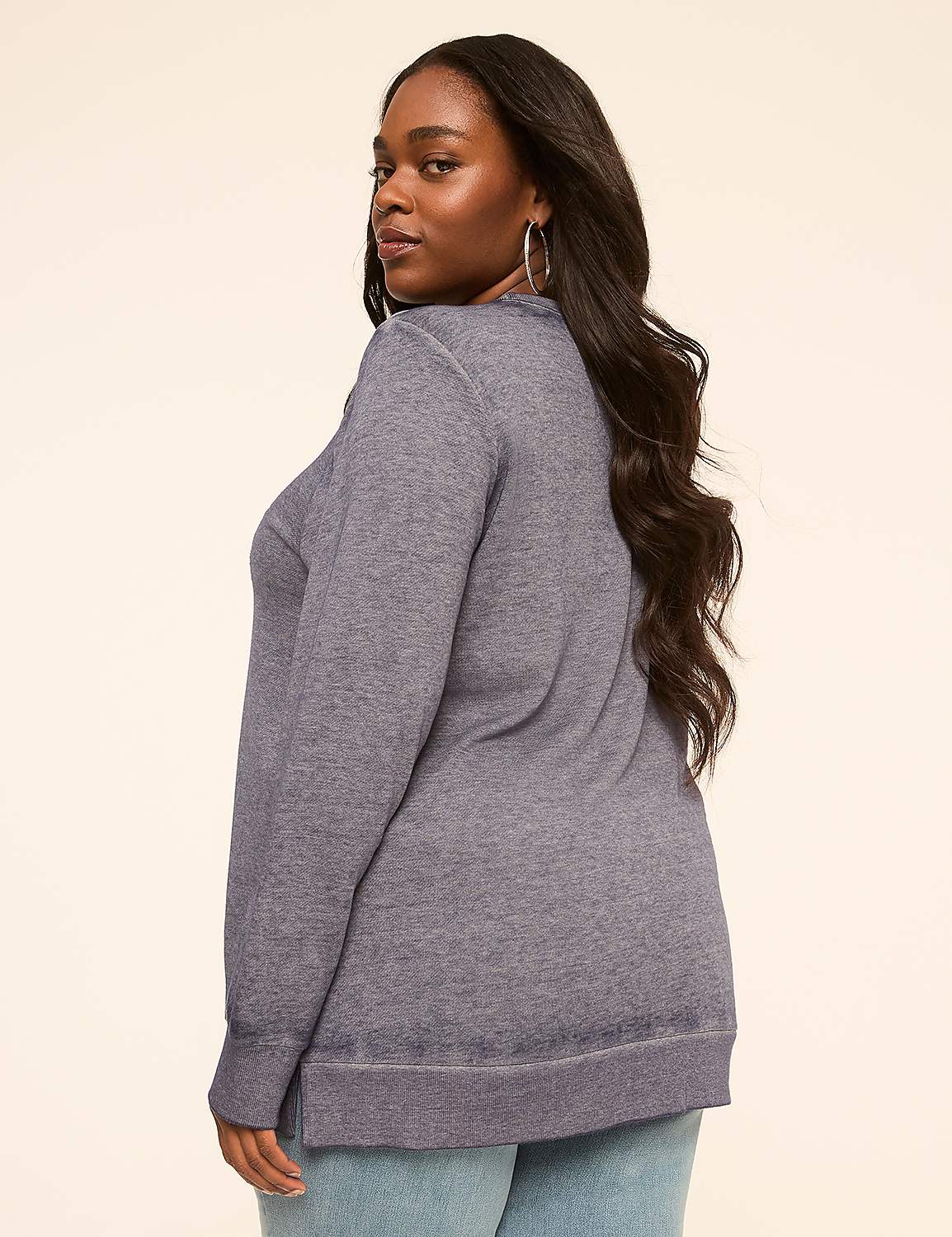 A woman in a blue sweatshirt and jeans stands against a plain, light-colored background. Product Image 2