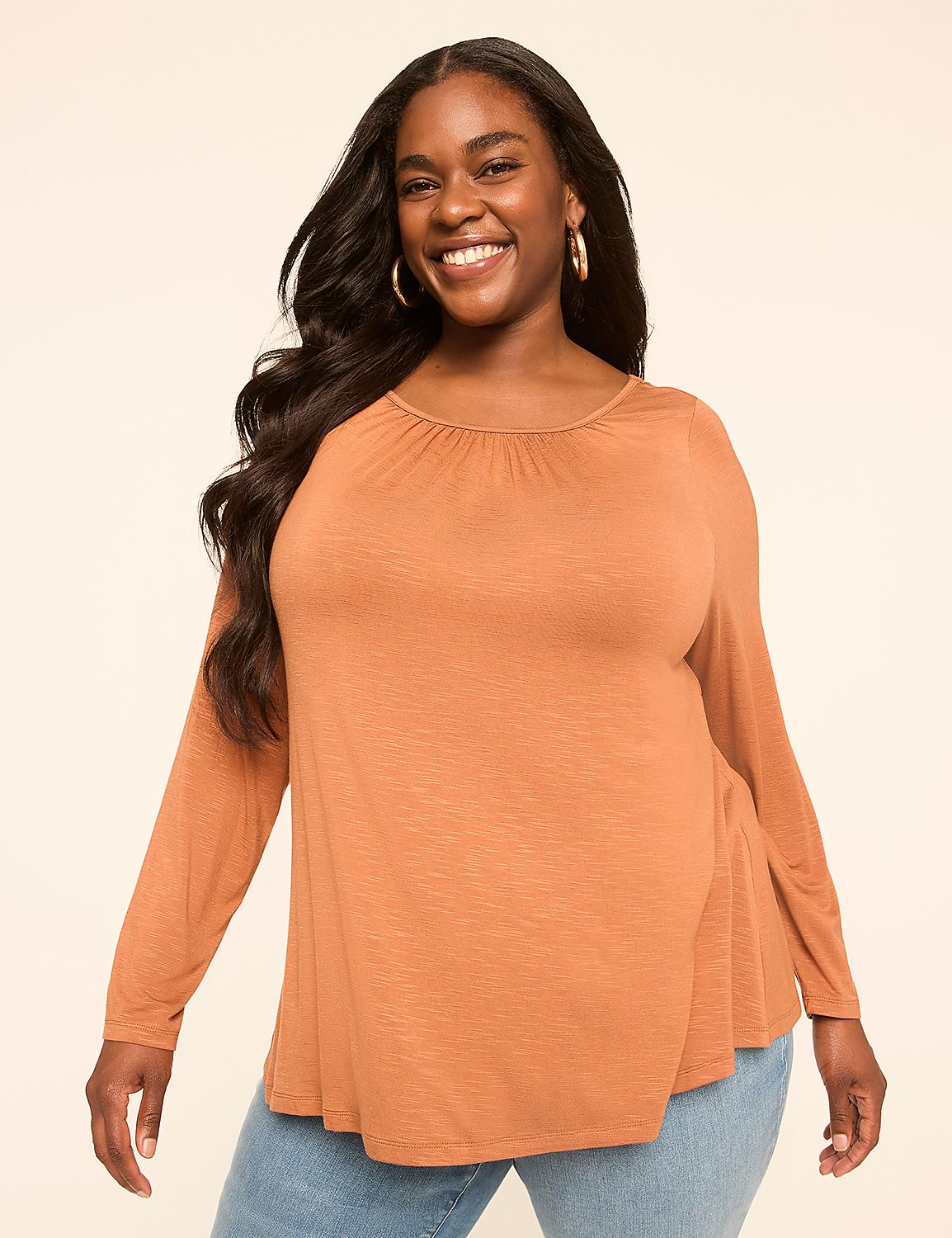 A smiling woman with long dark hair wears an orange long-sleeved shirt and blue jeans against a plain beige background. Product Image 1