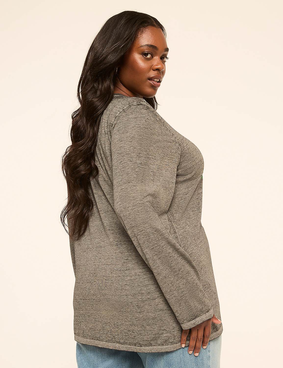 A woman with long, dark hair wearing a gray long-sleeved shirt and blue jeans poses against a plain, light-colored background. Product Image 2