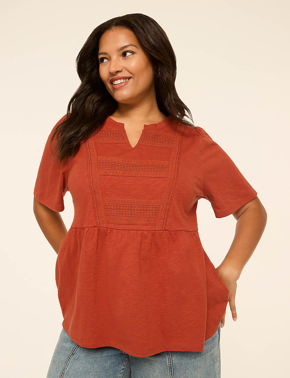 A smiling woman in a rust-colored peasant top stands against a plain, light-colored background. Product Image 1