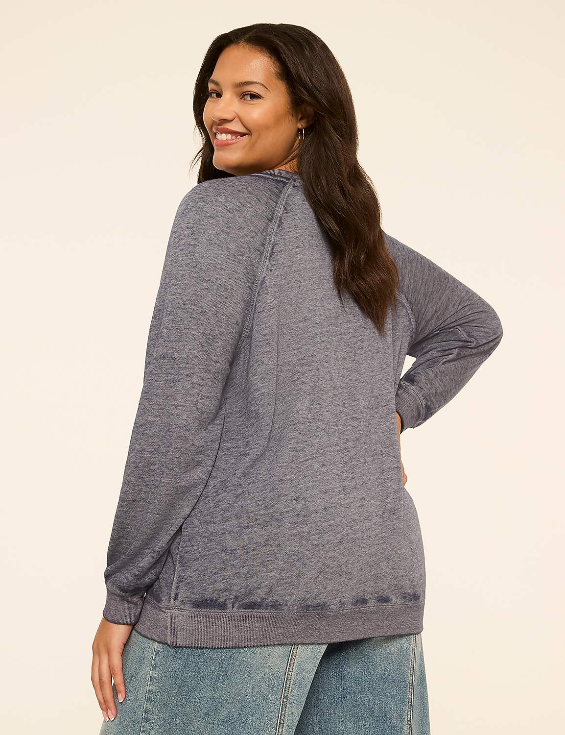 A woman in a blue sweatshirt and jeans stands against a plain cream background. Product Image 2
