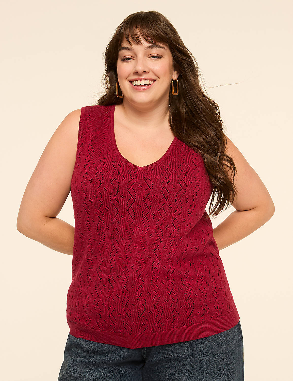 A smiling woman in a maroon v-neck sweater stands against a plain, light-colored background. Product Image 1