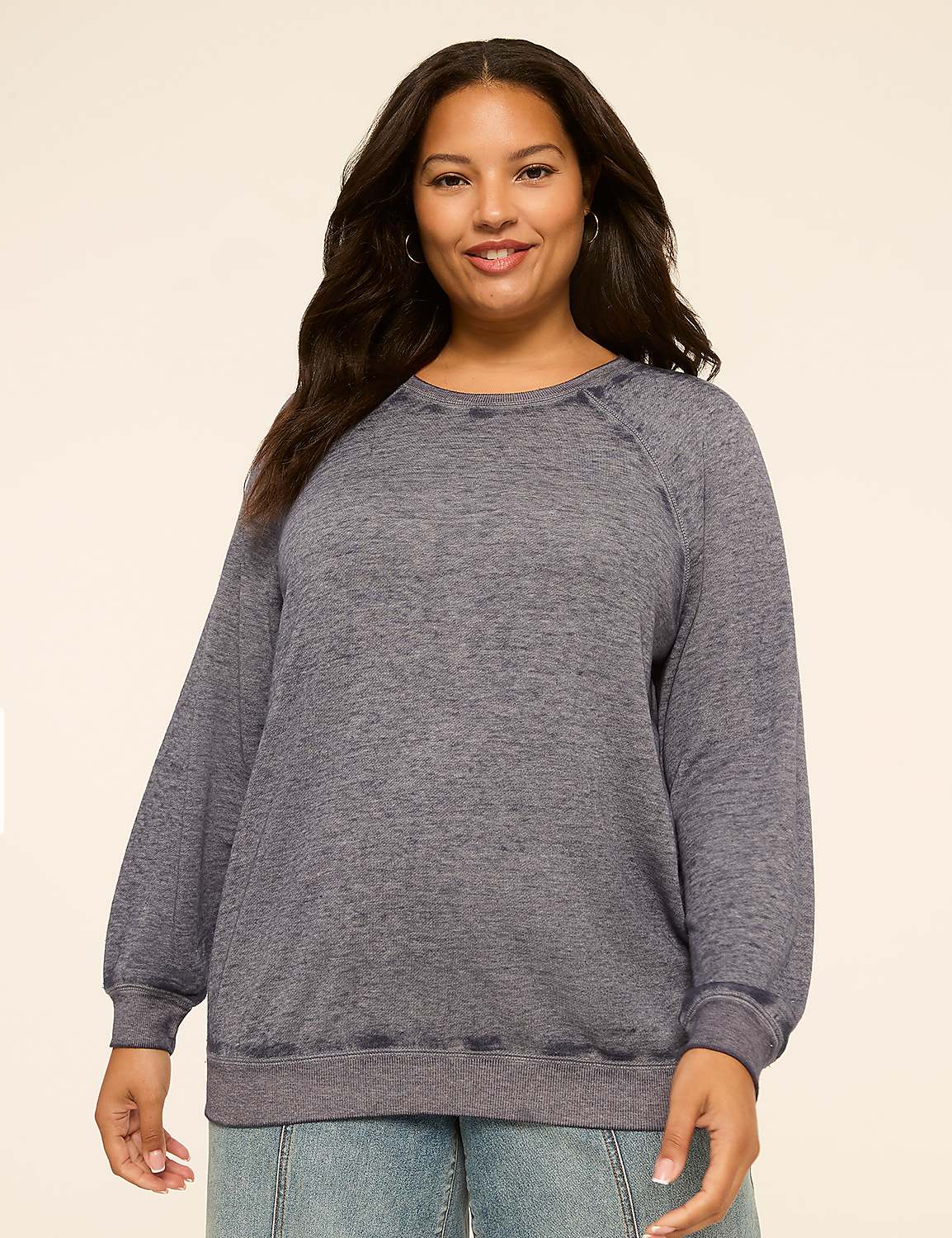 A smiling woman in a gray sweatshirt stands against a plain, light-colored background. Product Image 1