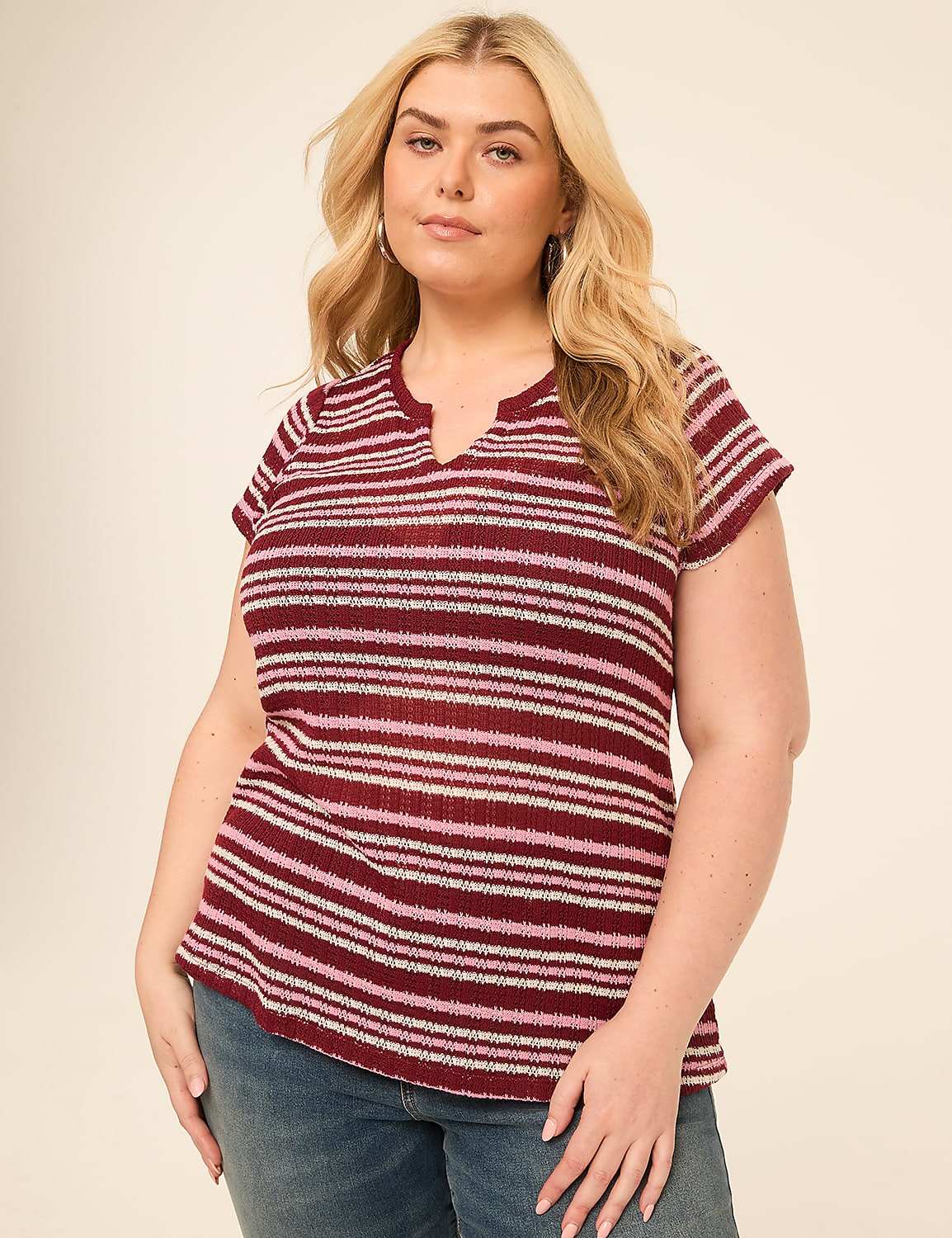 A woman with blonde hair and a striped shirt stands against a plain, light-colored background. Product Image 1