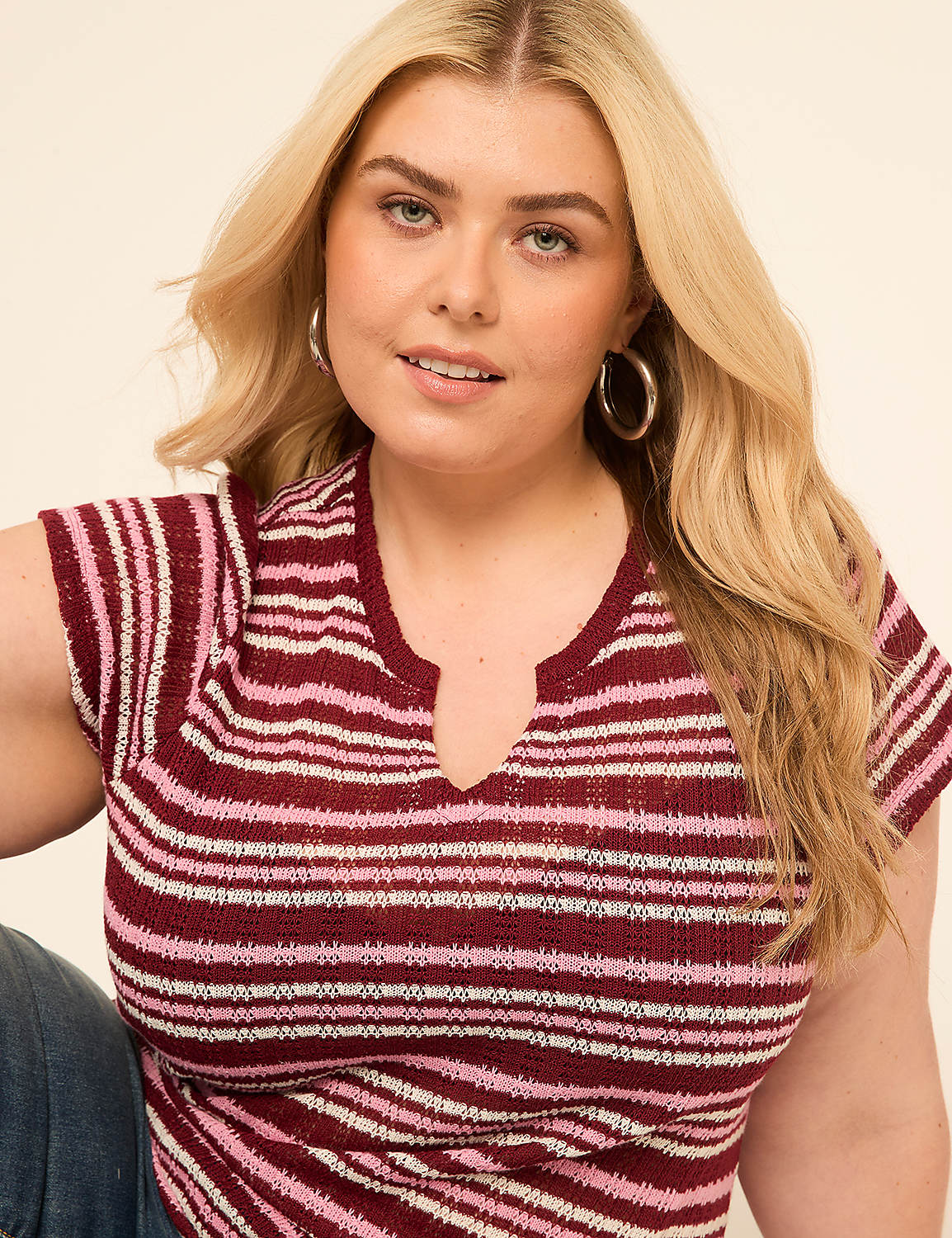 A blonde woman with hoop earrings wears a striped top in the foreground, against a plain, light-colored background. Product Image 4