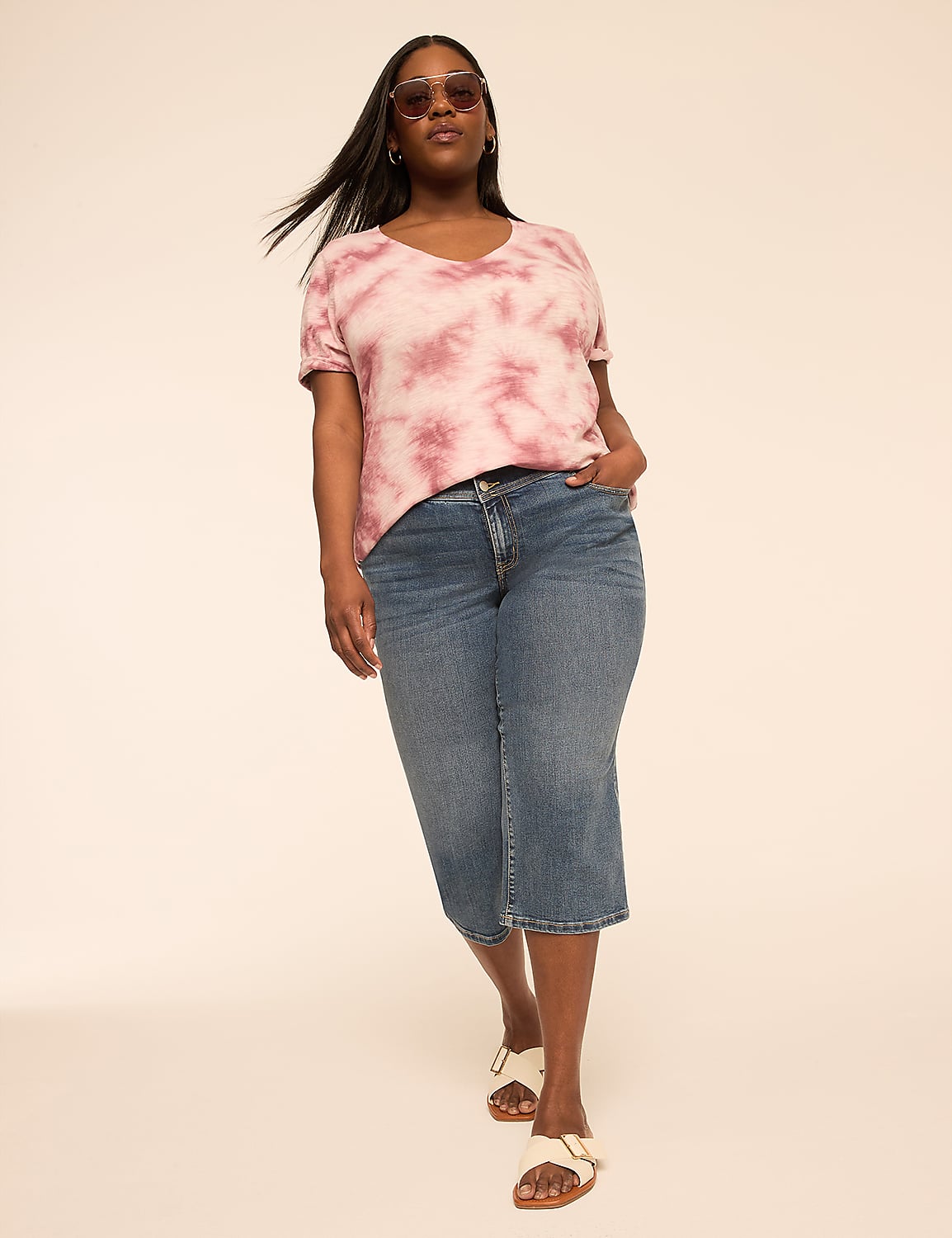 A woman in a tie-dye top and denim capris walks forward against a plain, light-colored background. Product Image 3