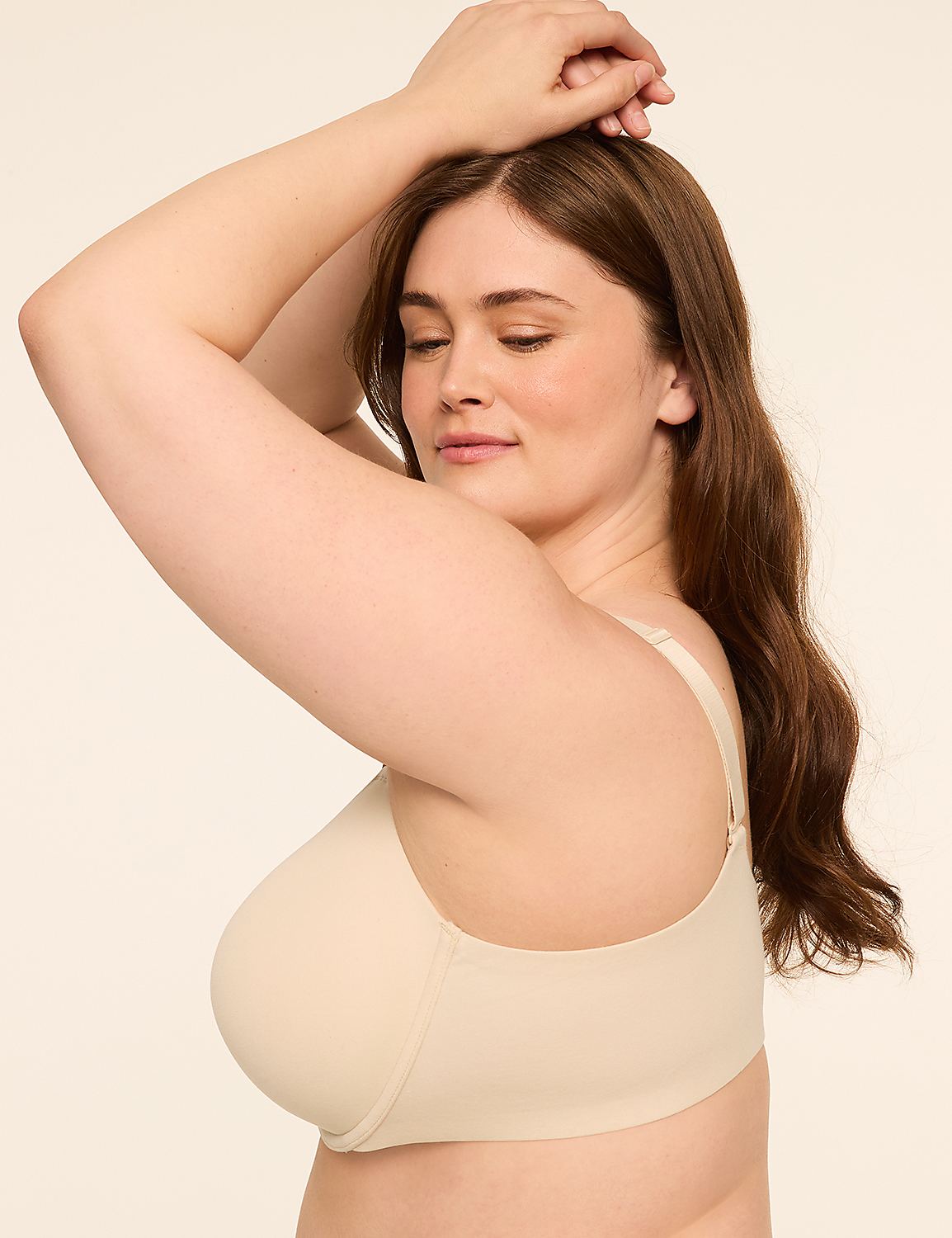 A woman with brown hair and closed eyes poses with her arms raised, wearing a beige bra against a plain, light-colored background. Product Image 3