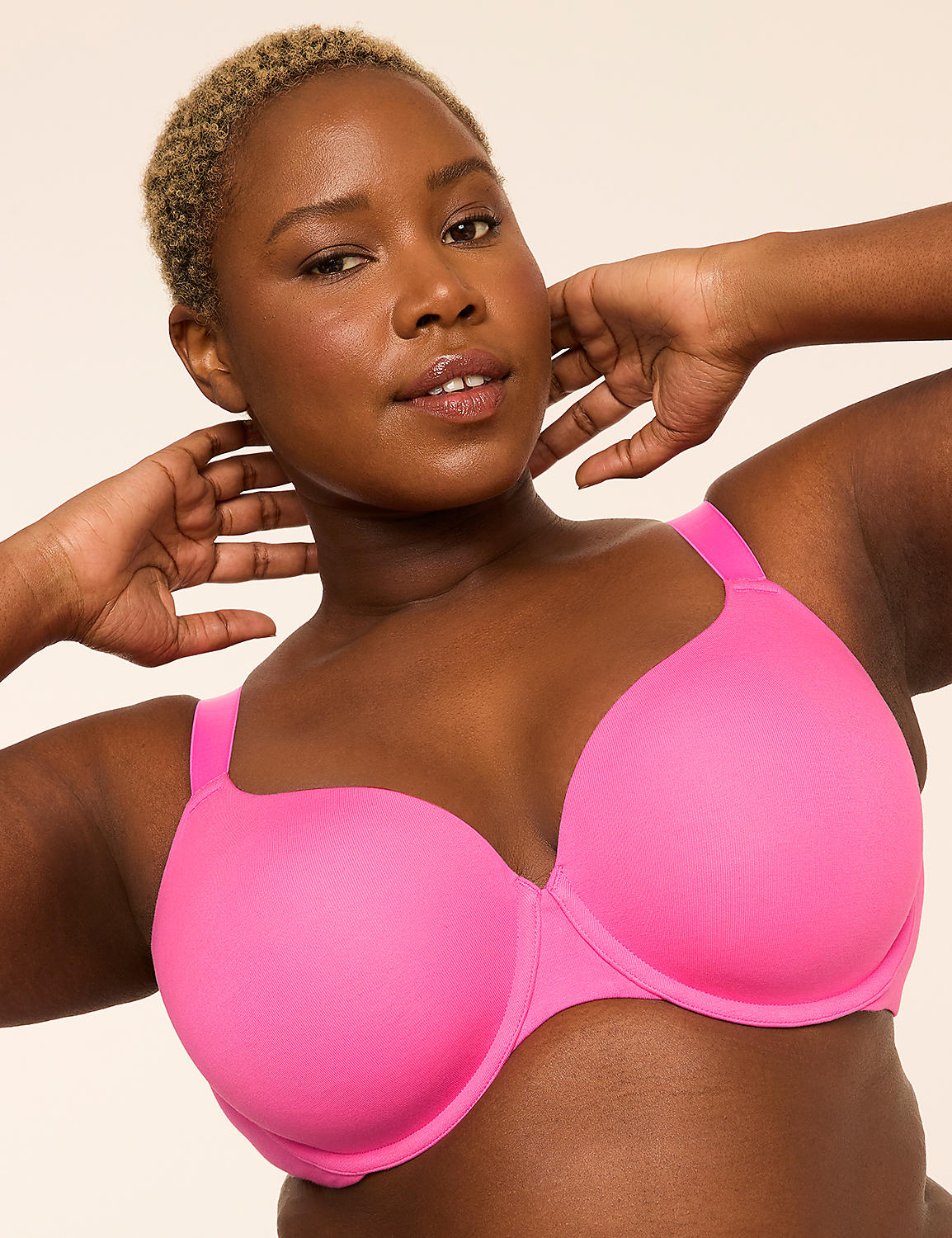 A woman with short blonde hair and dark skin poses in a bright pink bra against a plain, light background. Product Image 1