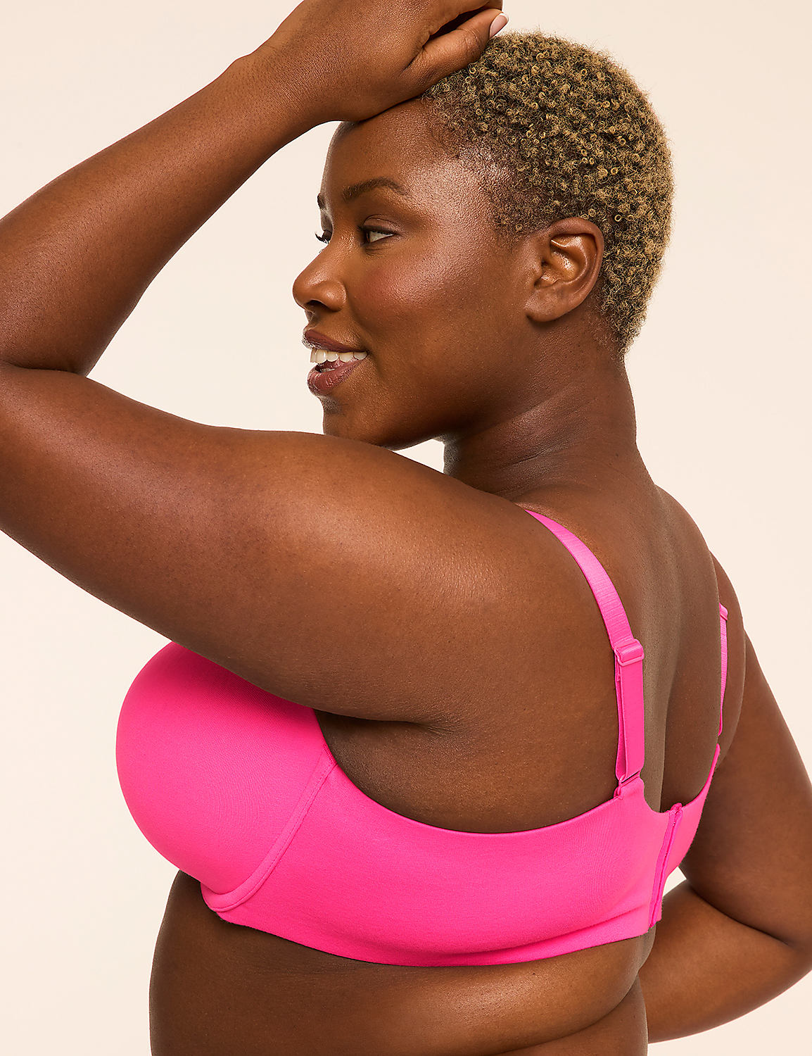 A woman with short, blonde hair smiles as she looks over her shoulder, wearing a bright pink bra against a plain, light background. Product Image 3