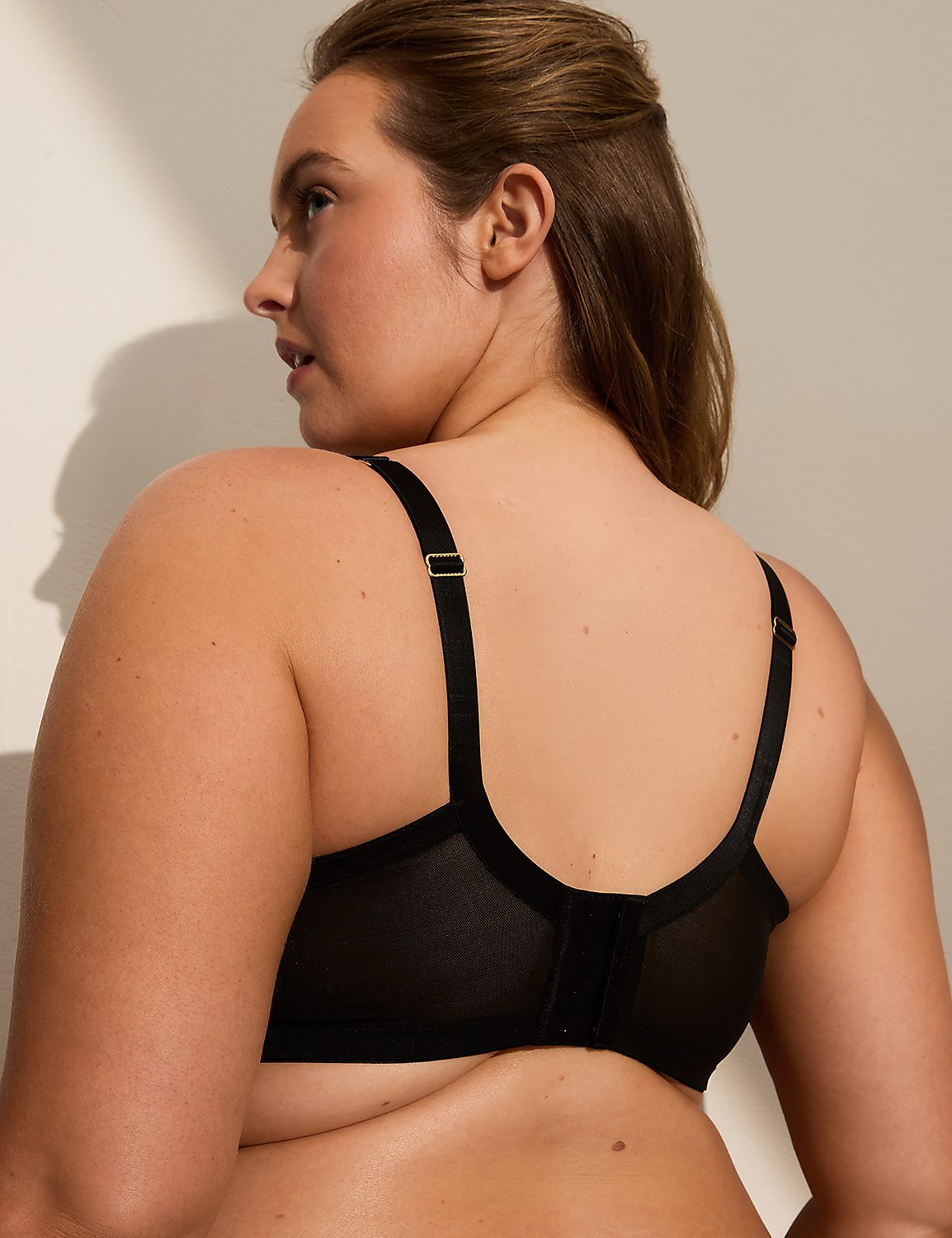 A woman's back is shown in the foreground, wearing a black bra, with a plain, light-colored background. Product Image 3