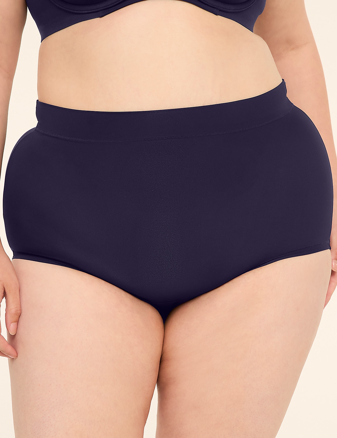 A person in navy blue high-waisted underwear stands against a plain, light-colored background. Product Image 1