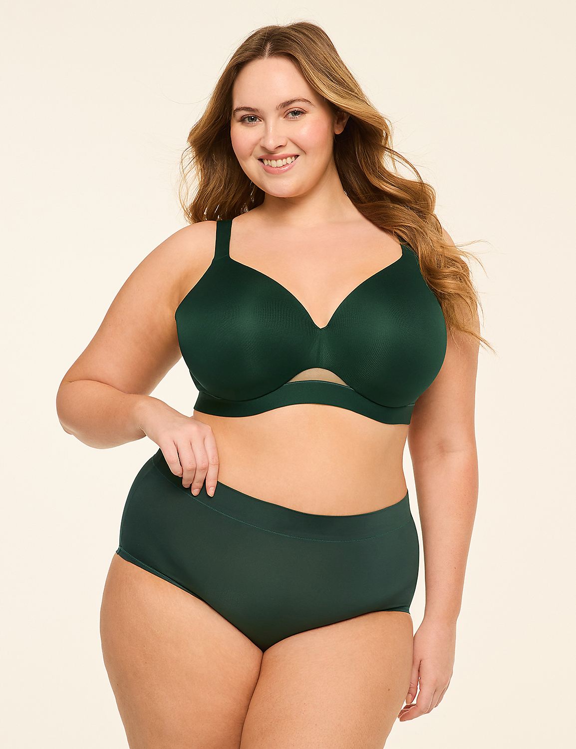 A smiling woman in a green bra and matching underwear stands against a plain, light-colored background. Product Image 4