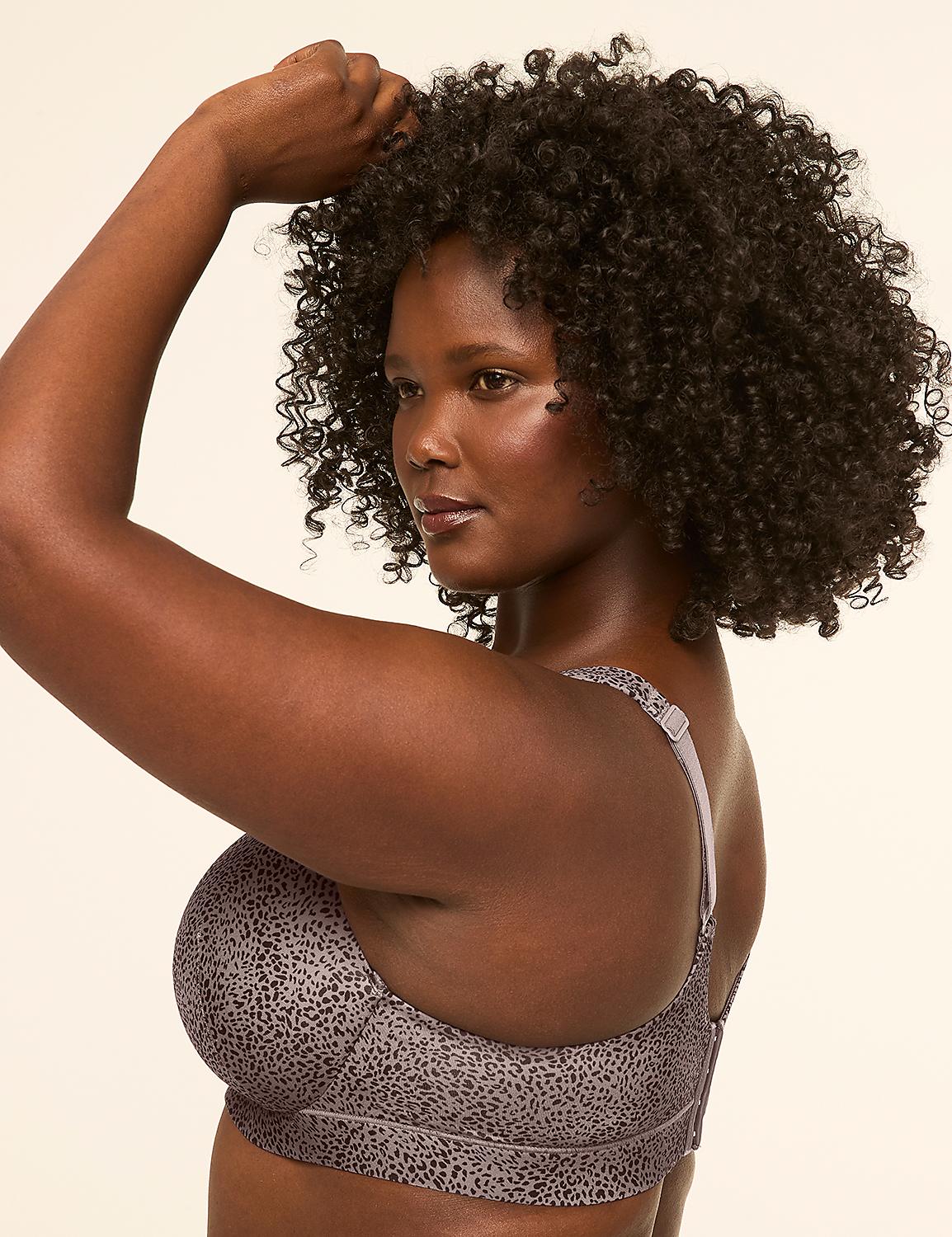 A woman with curly dark hair and a patterned bra flexes her arm against a plain, light-colored background. Product Image 3
