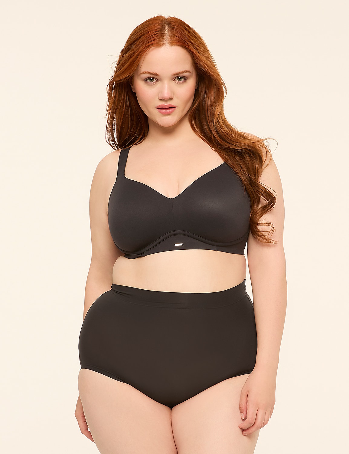 A woman with red hair stands in the foreground wearing a black bra and high-waisted underwear against a plain, light-colored background. Product Image 4