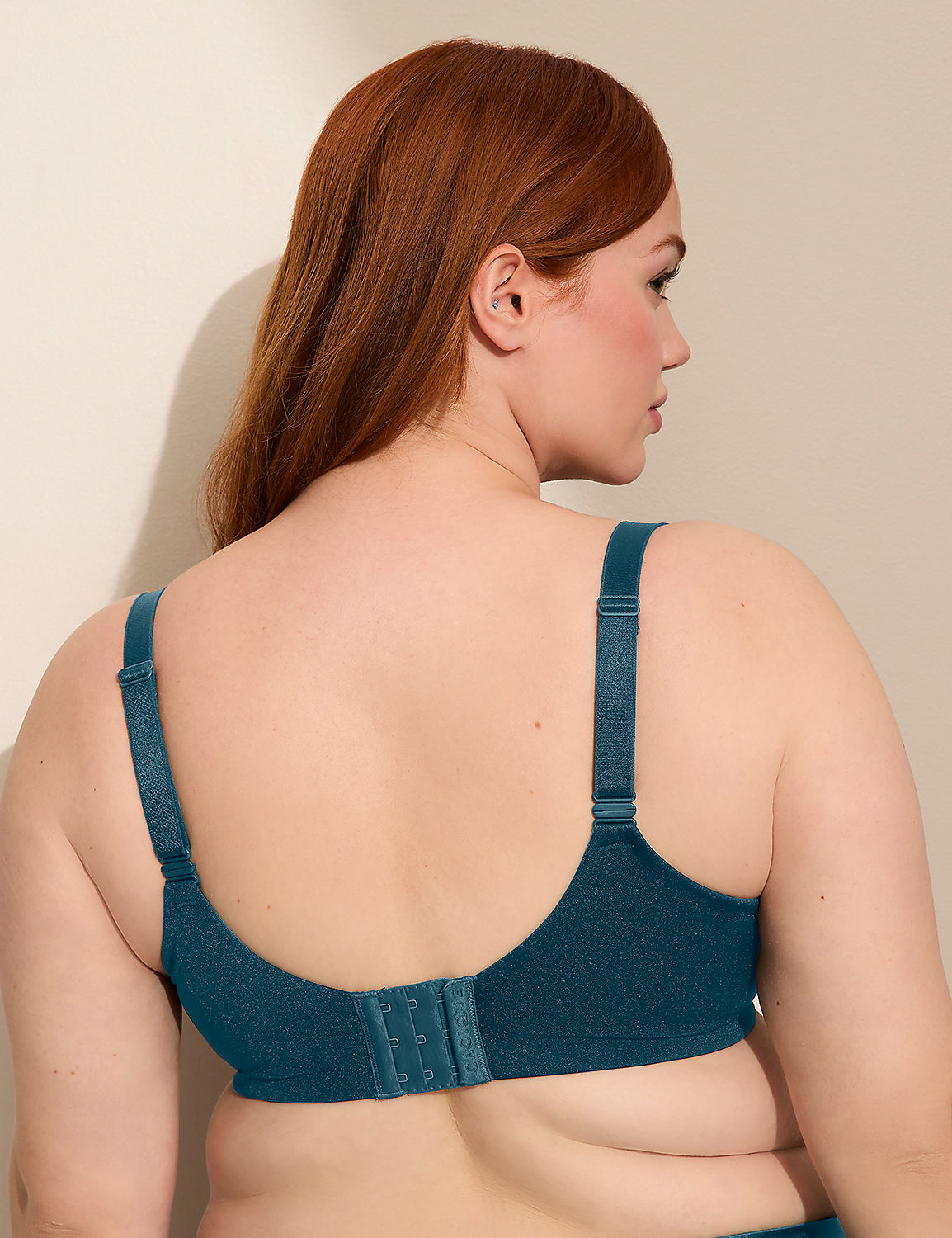 A woman with auburn hair is shown from the back, wearing a teal bra against a plain, light-colored wall. Product Image 3