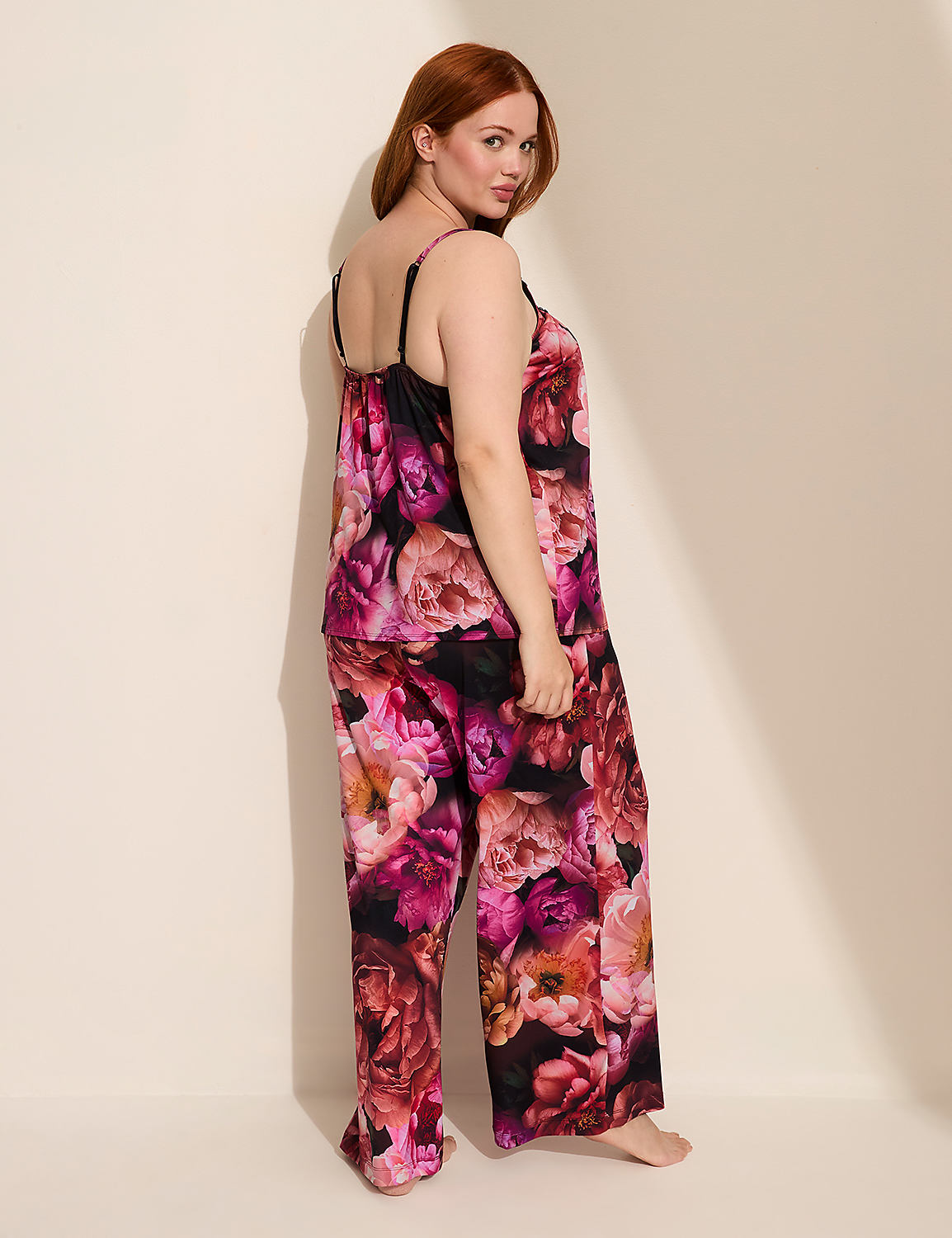 A woman with red hair poses in floral pajamas against a plain, light-colored wall. Product Image 2