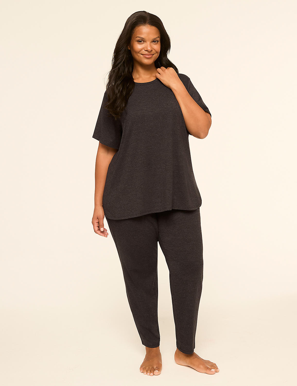 A smiling woman in a dark grey loungewear set stands against a plain, light-colored background. Product Image 1