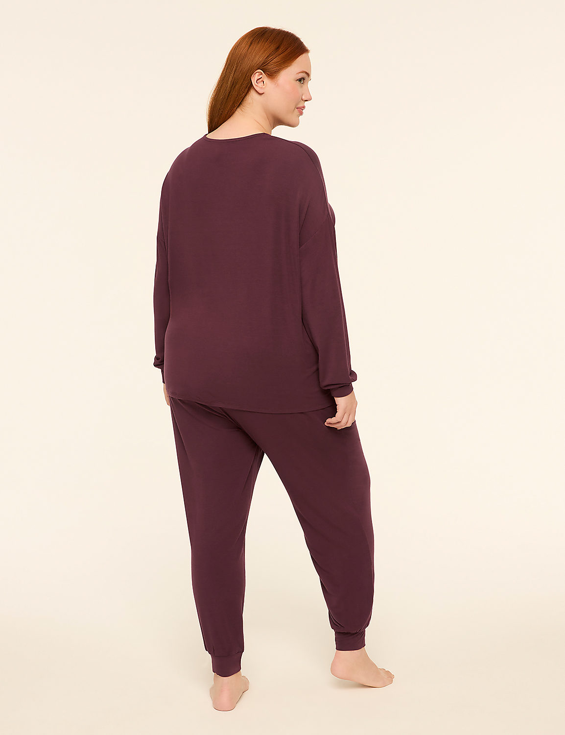 A woman with red hair stands facing away from the camera in a plum-colored loungewear set against a plain, light-colored background. Product Image 2
