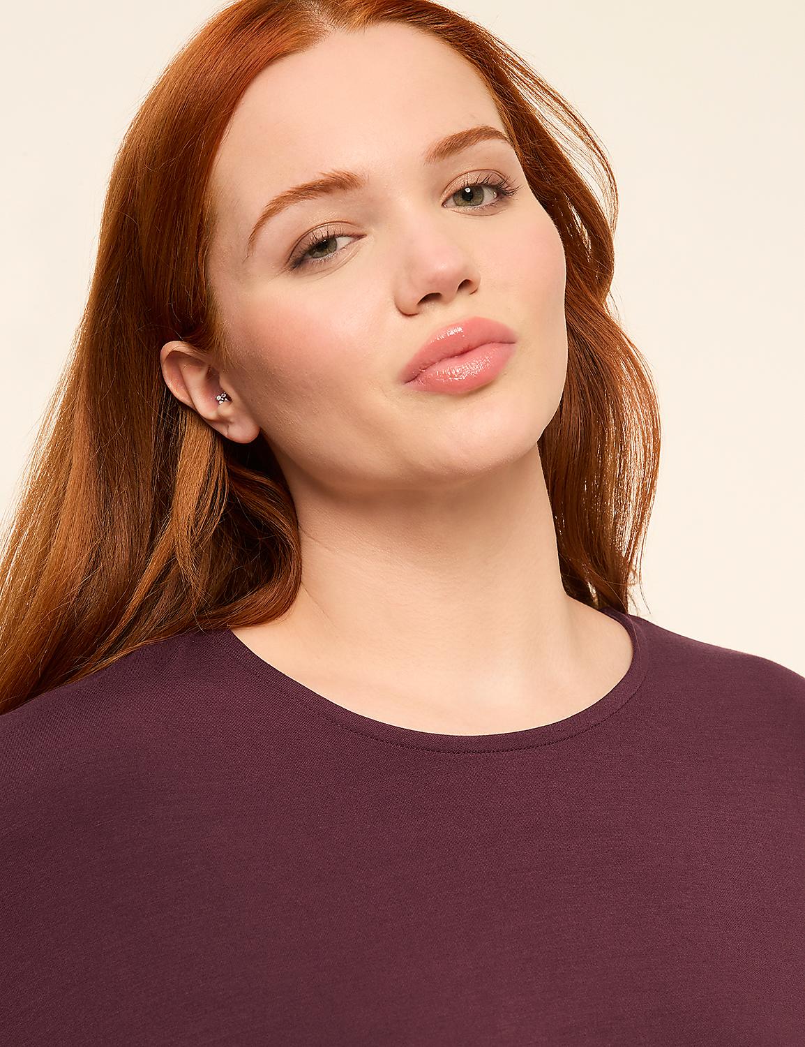 A woman with auburn hair and fair skin wears a plum-colored shirt against a plain, light background. Product Image 4