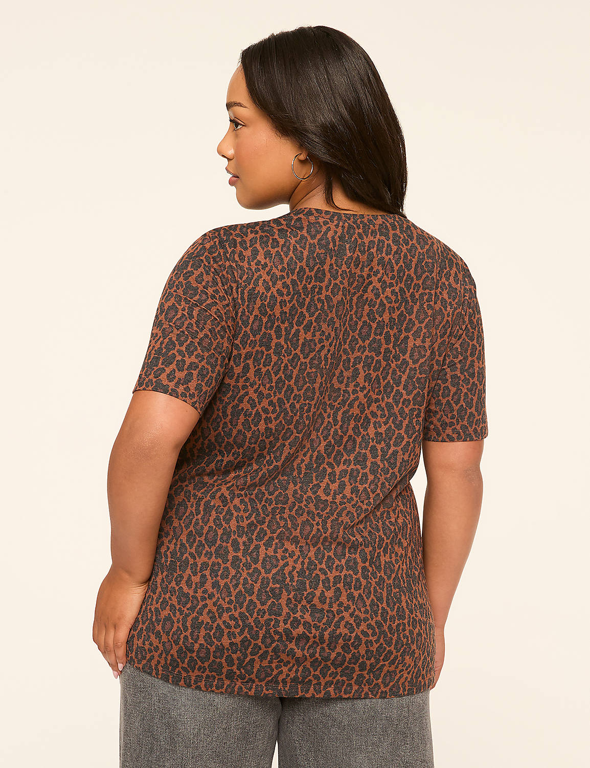 A woman in a brown leopard-print t-shirt stands against a plain, light-colored background. Product Image 2