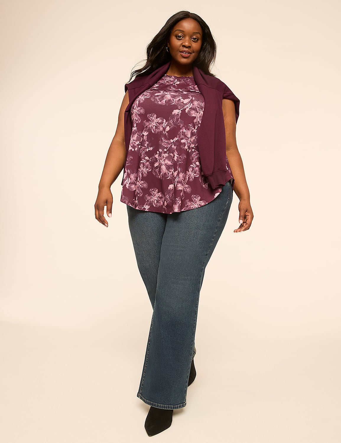 A woman in a floral top and jeans stands against a plain, light-colored background. Product Image 3