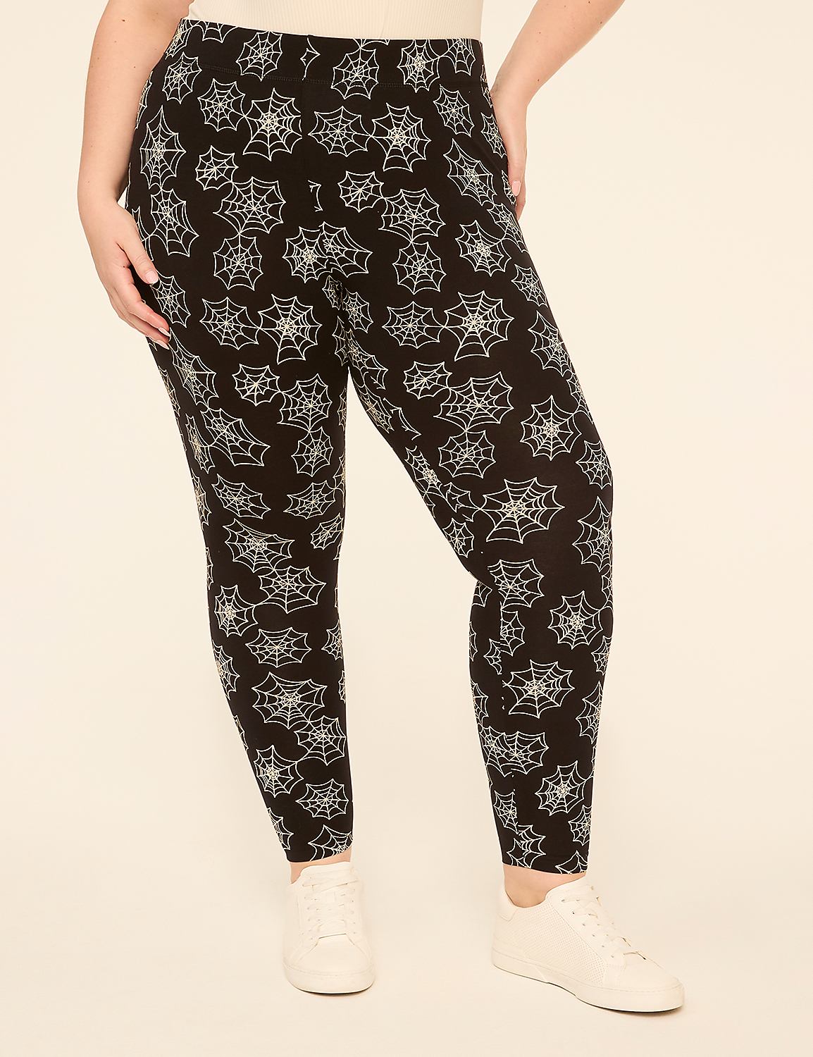 A person wearing black leggings with a white spiderweb pattern stands against a plain, light-colored background. Product Image 1