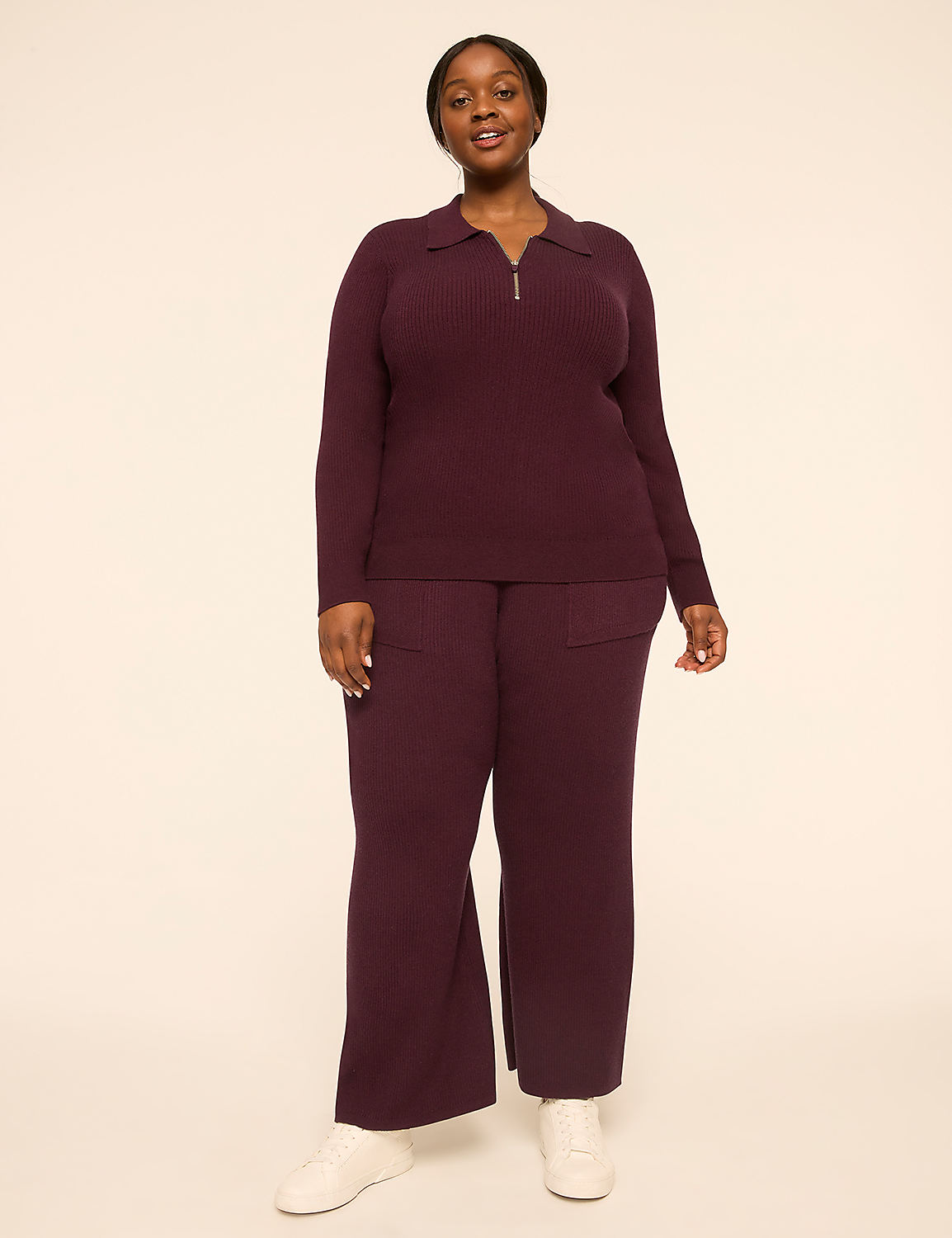 A woman in a burgundy knit set stands against a plain, light-colored background. Product Image 3